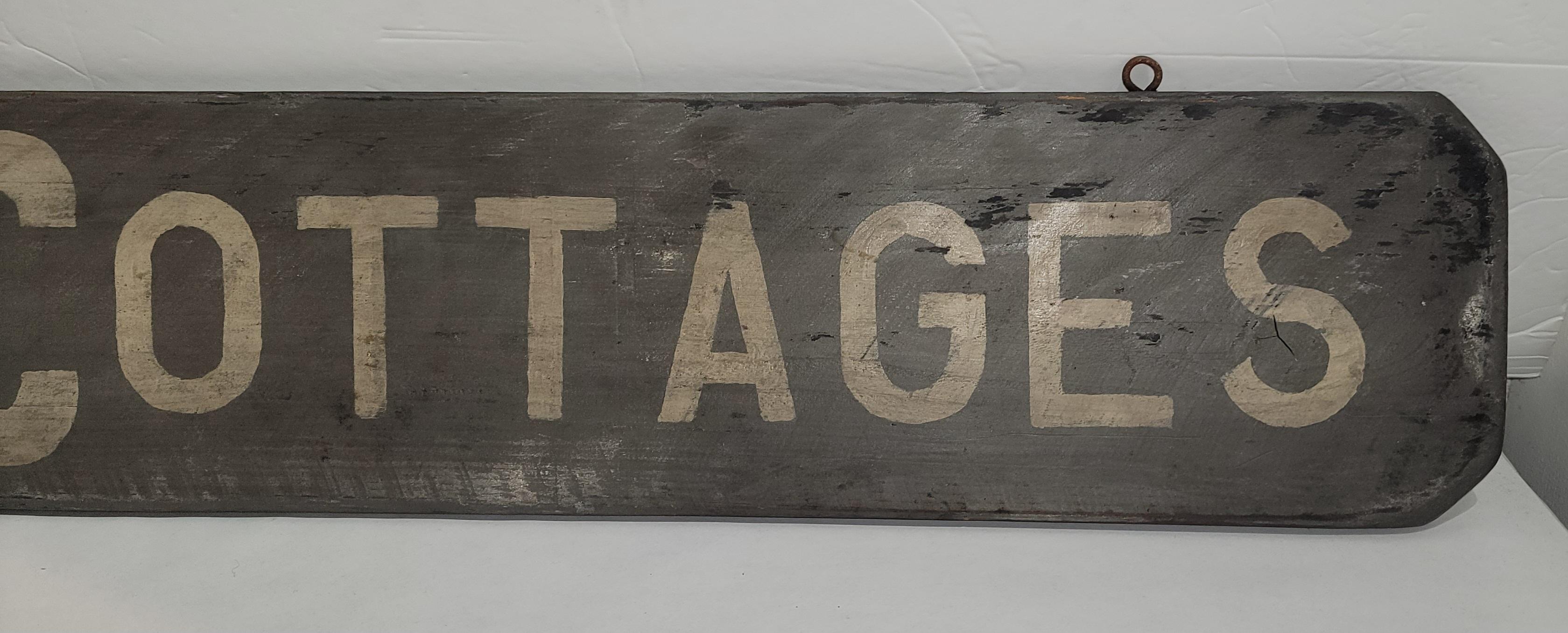 This cool 20th c Camps & Cottages trade sign or from a ranch or resort with original metal eyelets for handing. This is a hand painted & hand made sign.