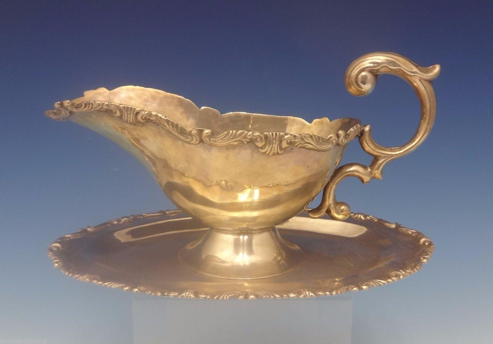Camusso of Peru sterling silver gravy boat with an attached underplate and thick scrolly border. Heavy handwrought piece. It measures 5 tall by 10 long and weighs 16.1 ozt. It dates from the 1940s. It is not monogrammed and is in excellent