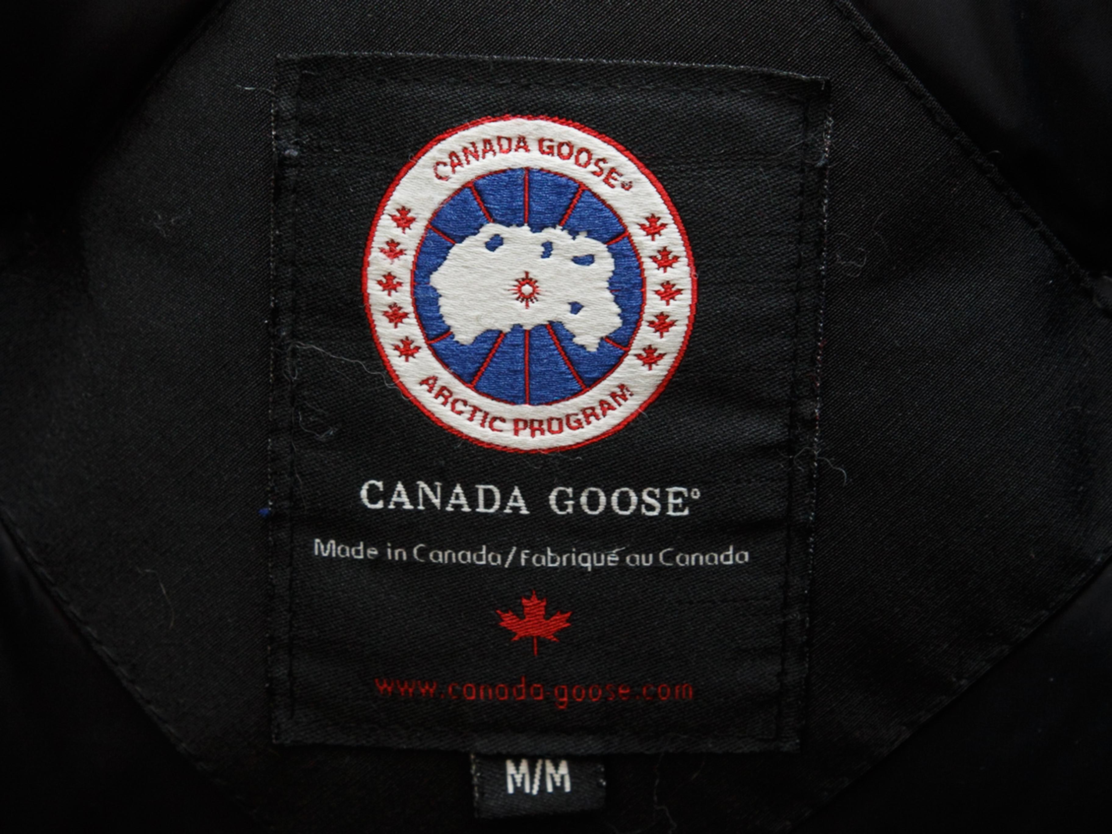 Product details: Black down-filled jacket by Canada Goose. Four pockets. Fur-trimmed hood. Concealed zip closure at center front. 42