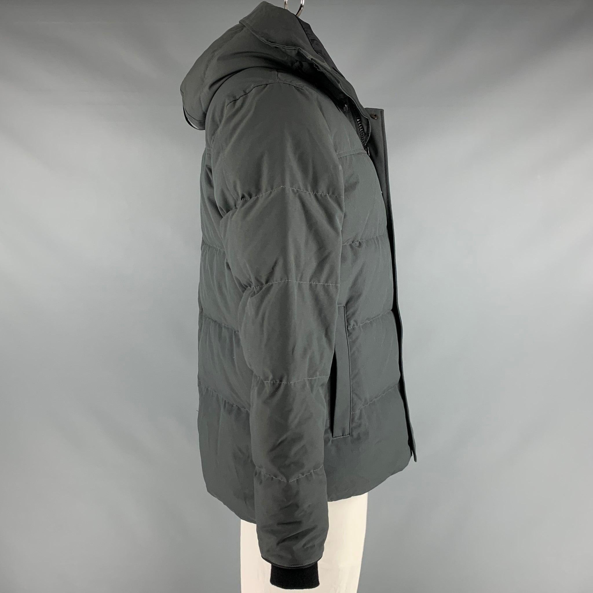 CANADA GOOSE jacket
in a grey polyester cotton blend fabric featuring quilted look, cozy duck down filling, hooded style, and a zip and snap closure. Made in Canada.Very Good Pre-Owned Condition. Minor signs of wear. 

Marked:   XL 

Measurements: 
