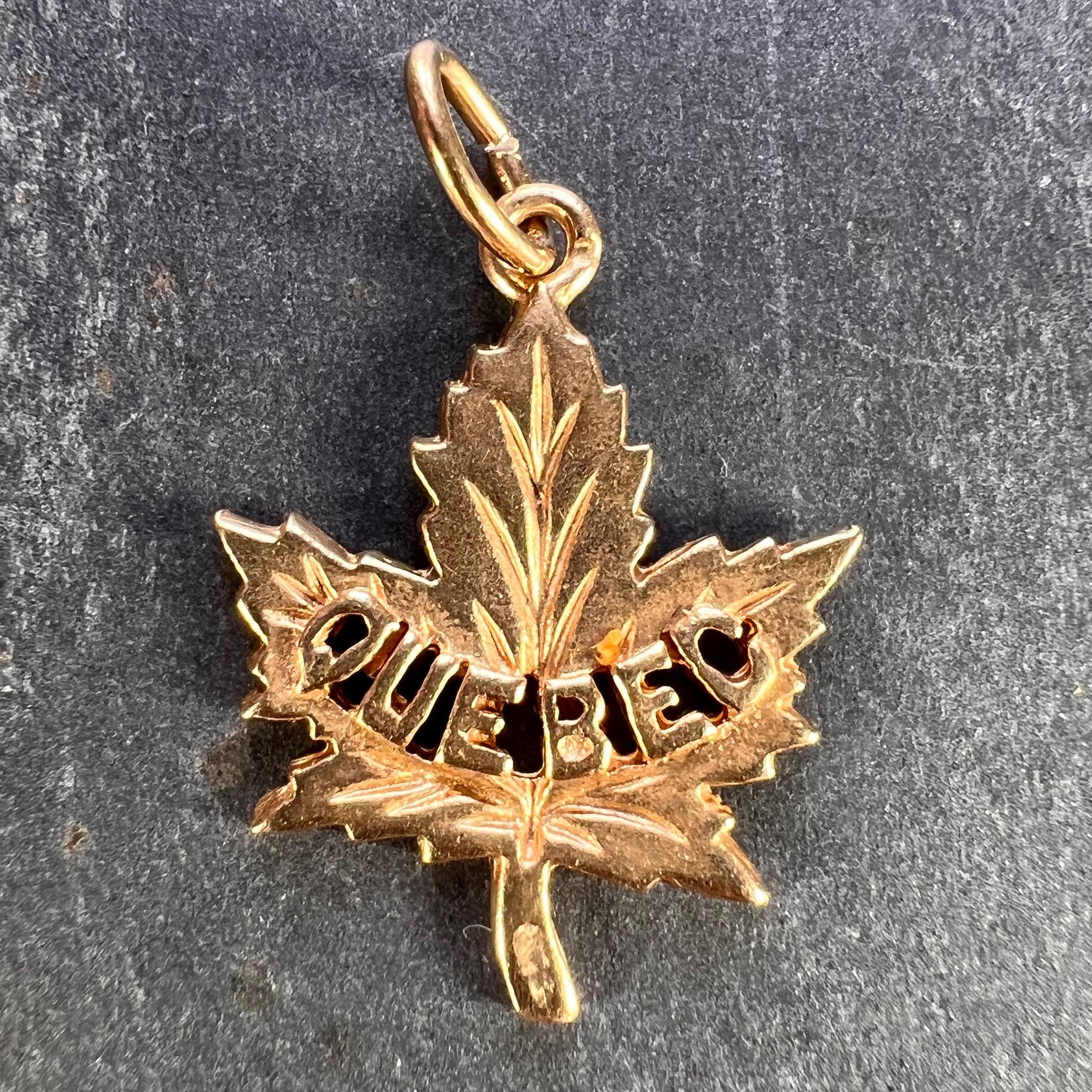 A 14 karat (14K) yellow gold charm pendant designed as a Canadian maple leaf with Quebec written across the front in block capitals. Marked 14K for 14 karat gold with an unknown maker's mark and a French import mark for 14 karat gold.

Dimensions: