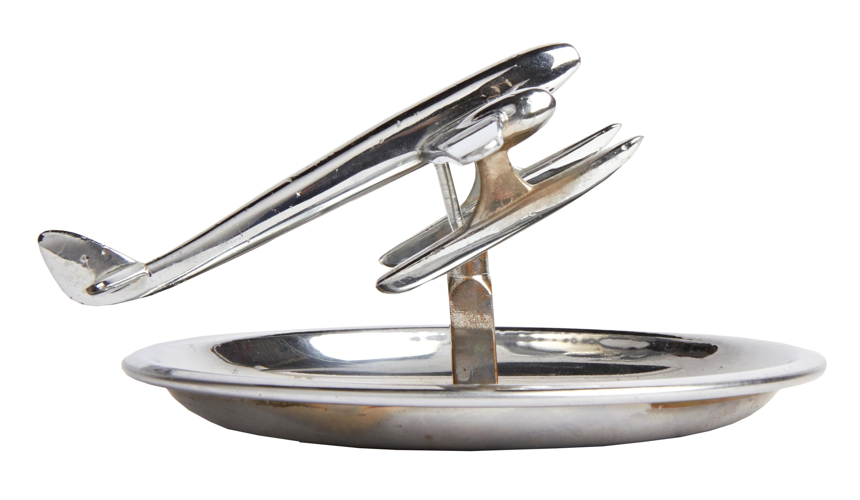 This iconic circular Canadian chrome plated ashtray features a ball jointed and poseable model of a seaplane mounted on a square sided pillar. This bears a trade mark with the initials 