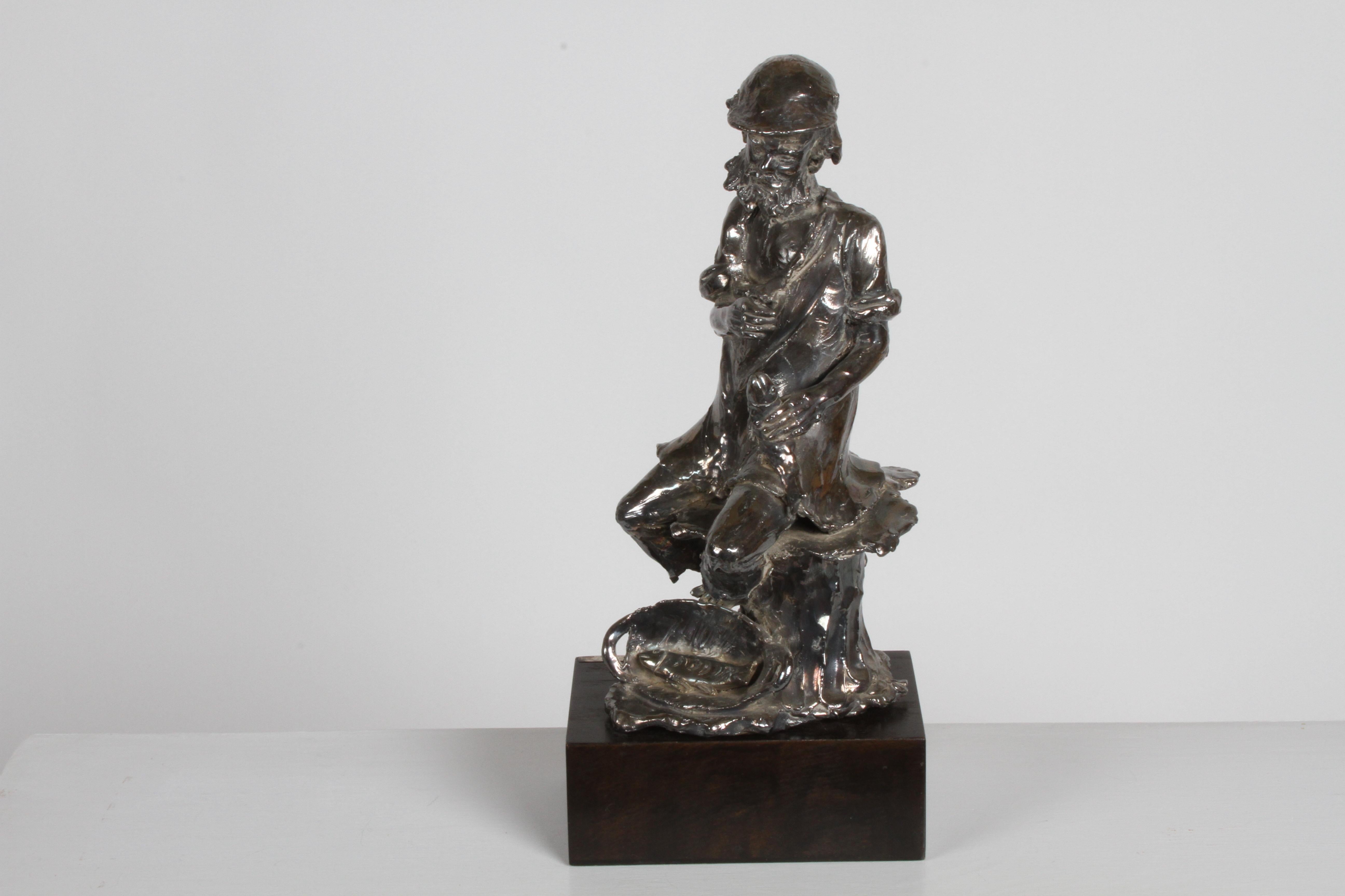 Una nota scultrice canadese, Alice Winant (nata Czitron) Quebec, Canada/Romania 1928-1989, scultura unica in sterline 925 di un vecchio pescatore barbuto seduto su un ceppo, con in mano un pesce. Targa in sterling firmata a mano su base in legno A.