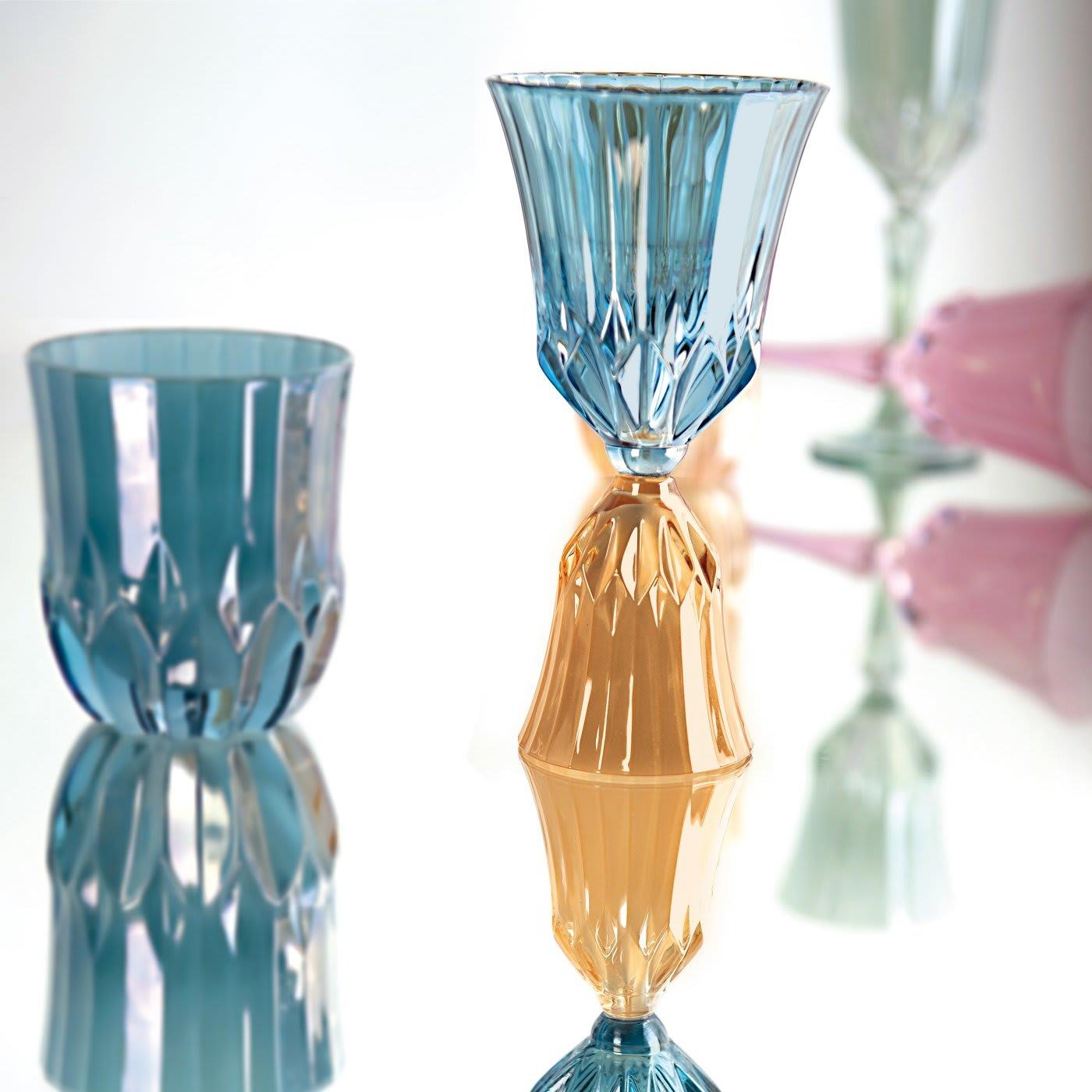 A striking showcase of craftsmanship, each water glass of this set of six boasts a low profile entirely crafted by hand, enriched with exquisite engravings. Composed of six different colors, this set is part of the Riflessi Collection of refined