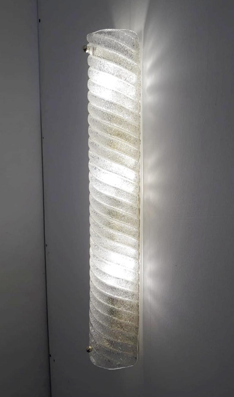 Italian wall light or flushmount with clear curved and ribbed Murano glass hand blown in Graniglia technique mounted on polished brass frame / Made in Italy circa 1960s by Barovier e Toso
Original mark on the frame
3 lights / E12 or E14 type / max