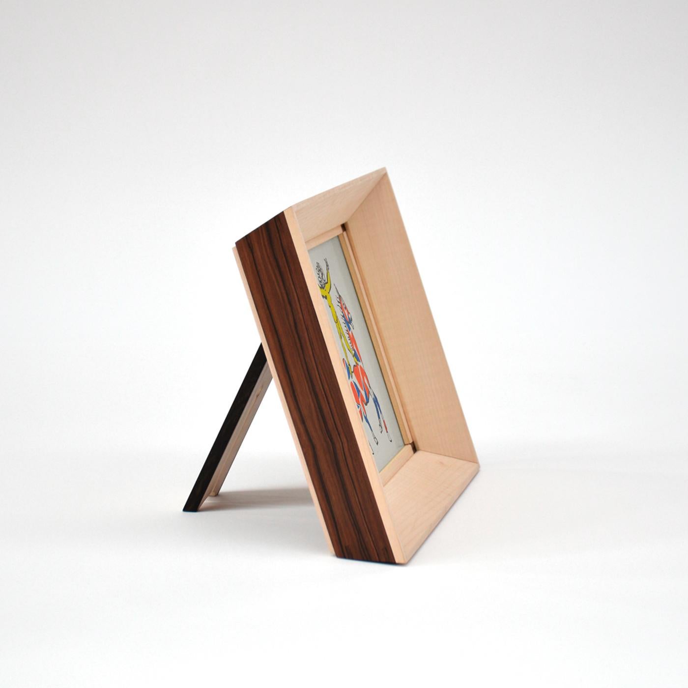 This square picture frame will lend class and sophistication to any room while displaying cherished memories of momentous occasions. Handcrafted of ebony and maple, it sports simple lines enriched by the contrasting hues of the two woods. The