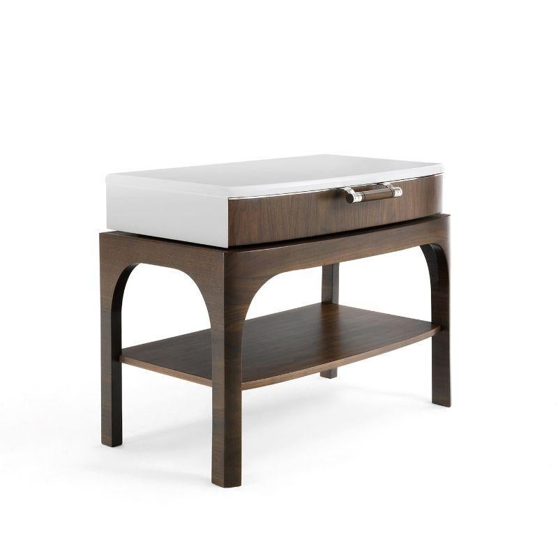 This gorgeous bedside table is defined by clean and minimalist lines of rounded profile and will be best paired with the dresser from the same series. Boasting a white-lacquered wooden top, it is fashioned of Canaletto walnut, also available in a