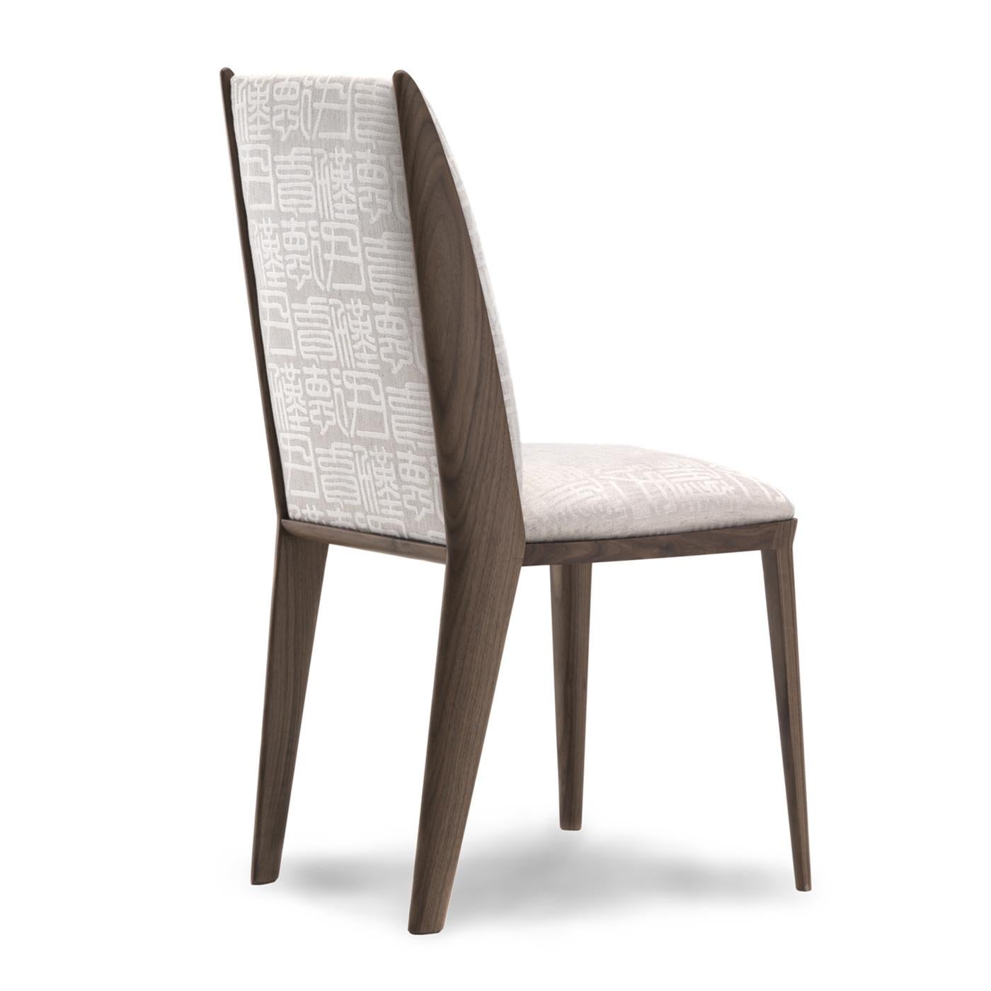 This sleek and elegant chair will ideally surround a contemporary-style table in a refined dining area, imbuing it with timeless sophistication. Handmade of Canaletto walnut, it features a clean silhouette with a softly padded seat and backrest,
