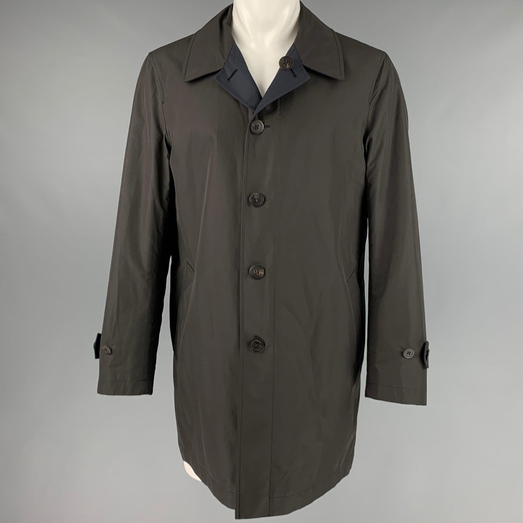 CANALI coat
in a
navy and brown polyester fabric featuring a two tone style, wind and light rain protection technology, and button closure, with hidden buttons on the navy side. Made in Italy.Very Good Pre-Owned Condition.
Minor marks on brown side.