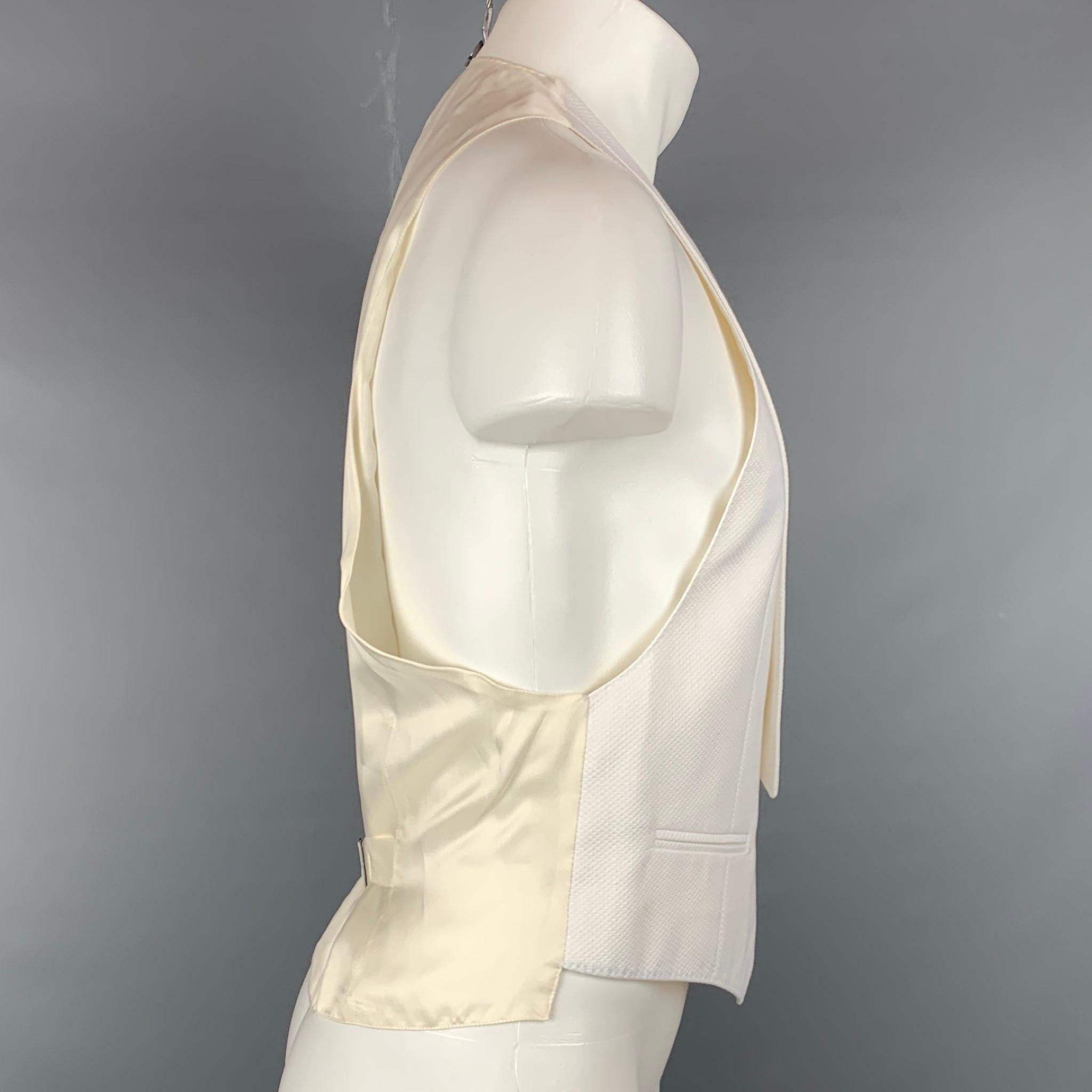 CANALI tuxedo vest comes in a white woven cotton with a full liner featuring a flap collar, slit pockets, and a buttoned closure. Made in Italy.

Very Good Pre-Owned Condition.
Marked: 54

Measurements:

Shoulder: 11.5 in.
Chest: 40 in.
Length: 22.5