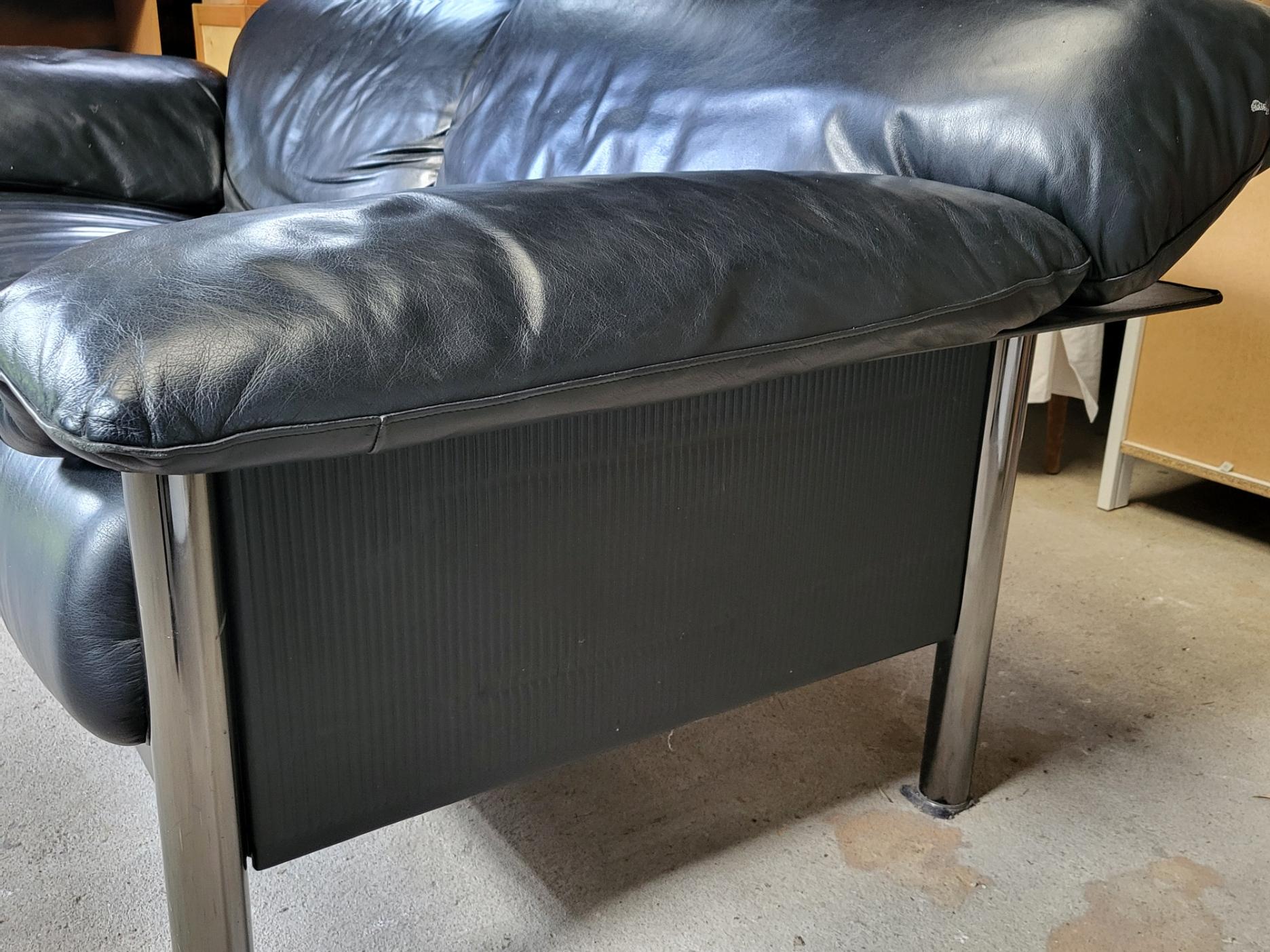 Canapè Pierluigi Cerri modello Pause, firmato Poltrona Frau, en cuir noir. Il design italiano del 1990, confezionato in pelle di alta qualità, presenta un aspetto ultramoderno, che poggia su piedini cilindrici cromati, con sfumature e imperfezioni