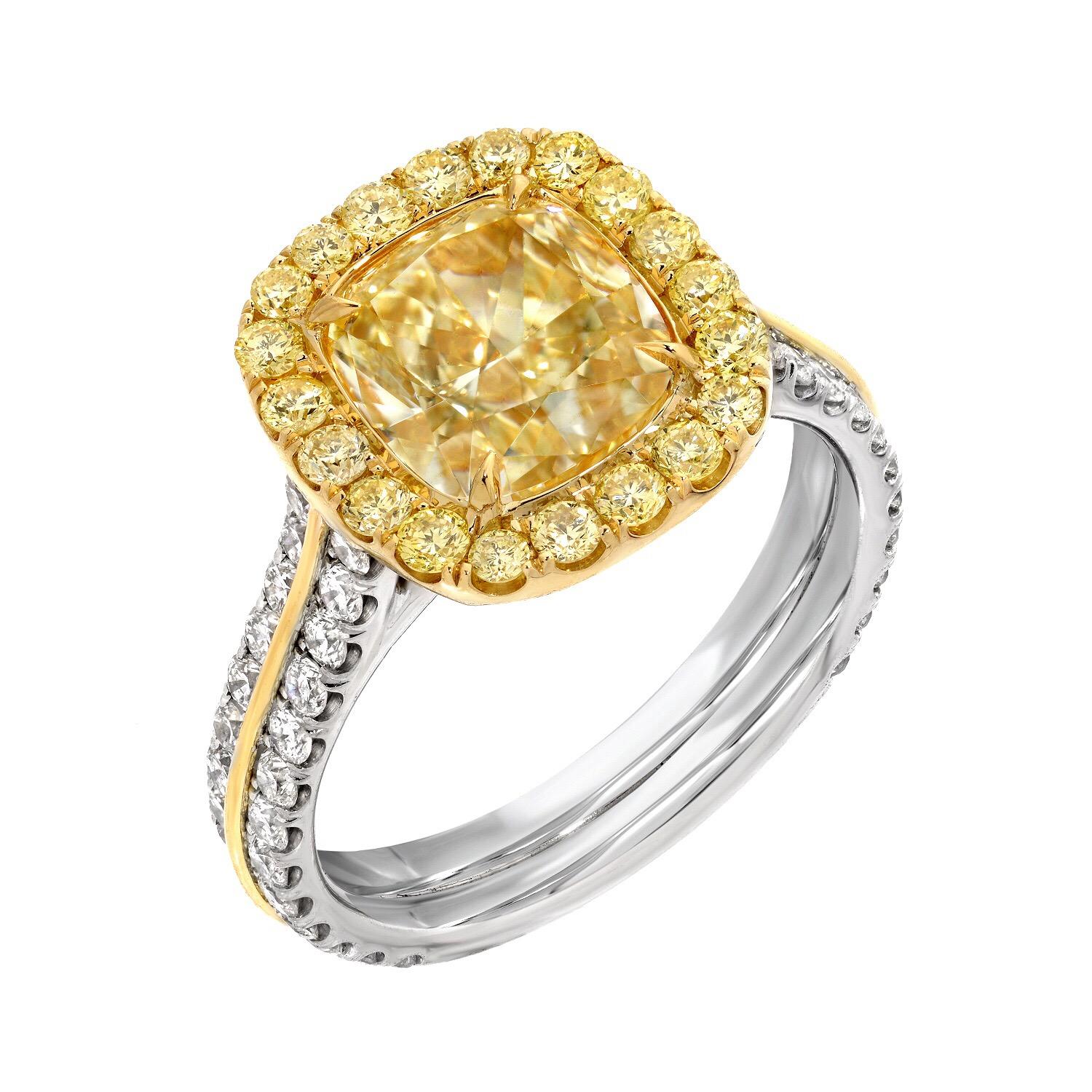 Platinum and 18K yellow gold ring, set with a supreme, G.I.A certified, 2.40 carat Fancy Light Yellow diamond cushion cut, VS2 clarity, surrounded by fancy yellow diamond rounds totaling 0.37 carats, and accented by round white diamonds totaling