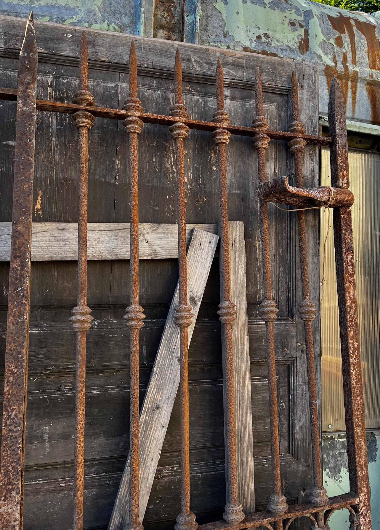 Antico Cancello in ferro battuto a due battenti, mantiene cardini e zanche in ferro originali (le parti da murare) e nottolini di decorazioni tornite sulle barre, originale di Epoca '800, provenienza Italia. 
Misure massime cm w 180 x H 218