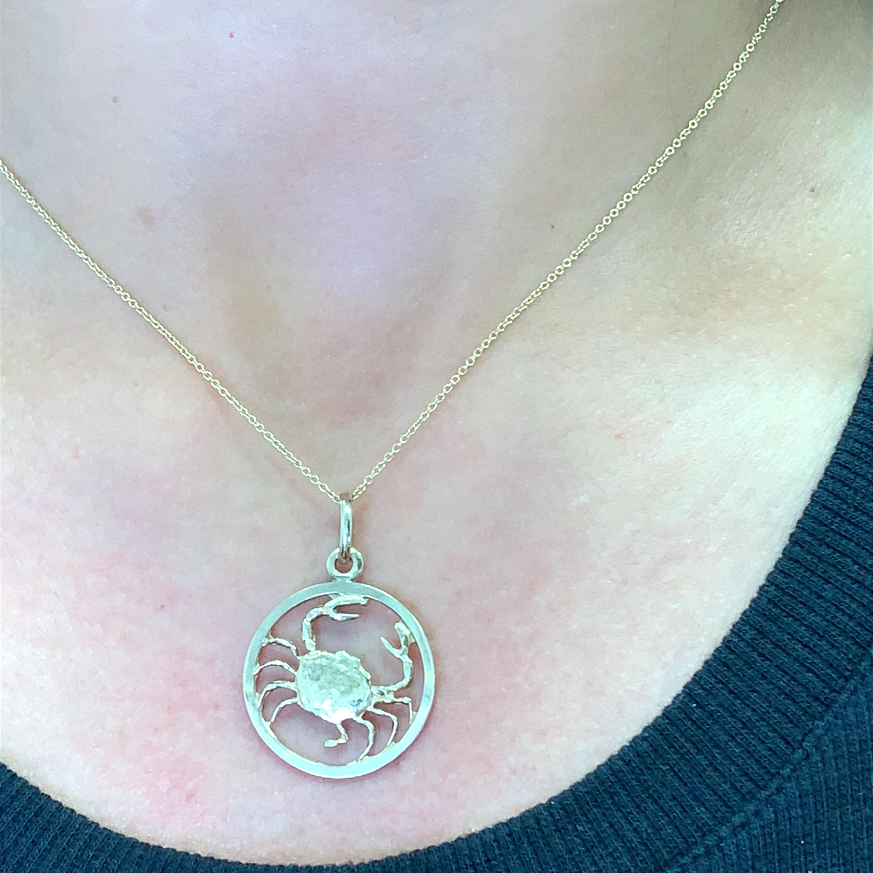 Adorn your neckline with this enchanting gold pendant, meticulously crafted in the shape of the Cancer zodiac sign. This astrological coin pendant jewel is a sophisticated statement piece, perfect for those who cherish personalized and meaningful