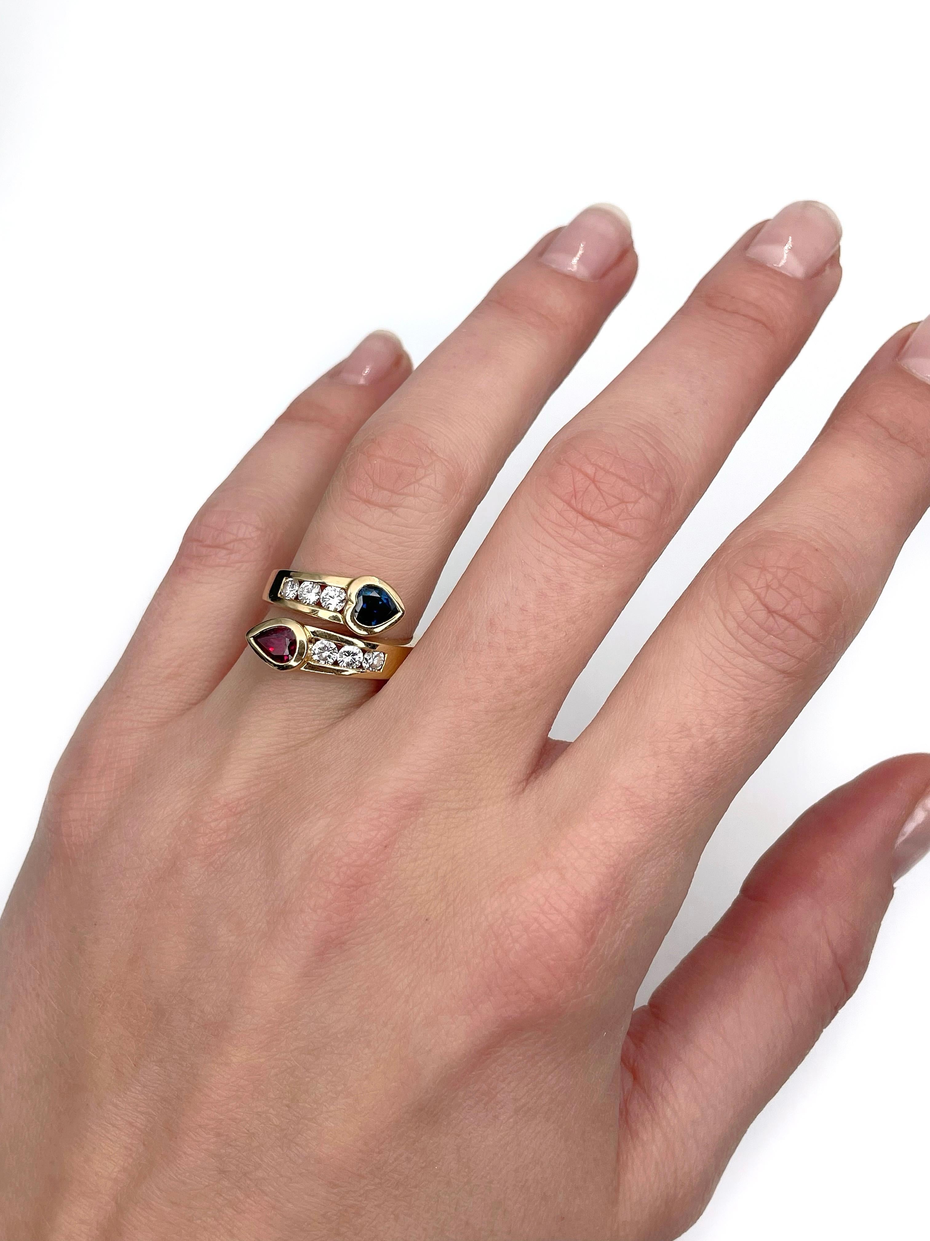 This is a modern design “Toi et moi” engagement ring designed by Spanish jewellery brand “Candame”. It is crafted in 18K gold. Circa 2000s. 

The piece features:
- 1 ruby: pear cut, 0.50ct, slpR 6/4, SI
- 1 sapphire: heart cut, 0.50ct, B 7/4, VS
- 6