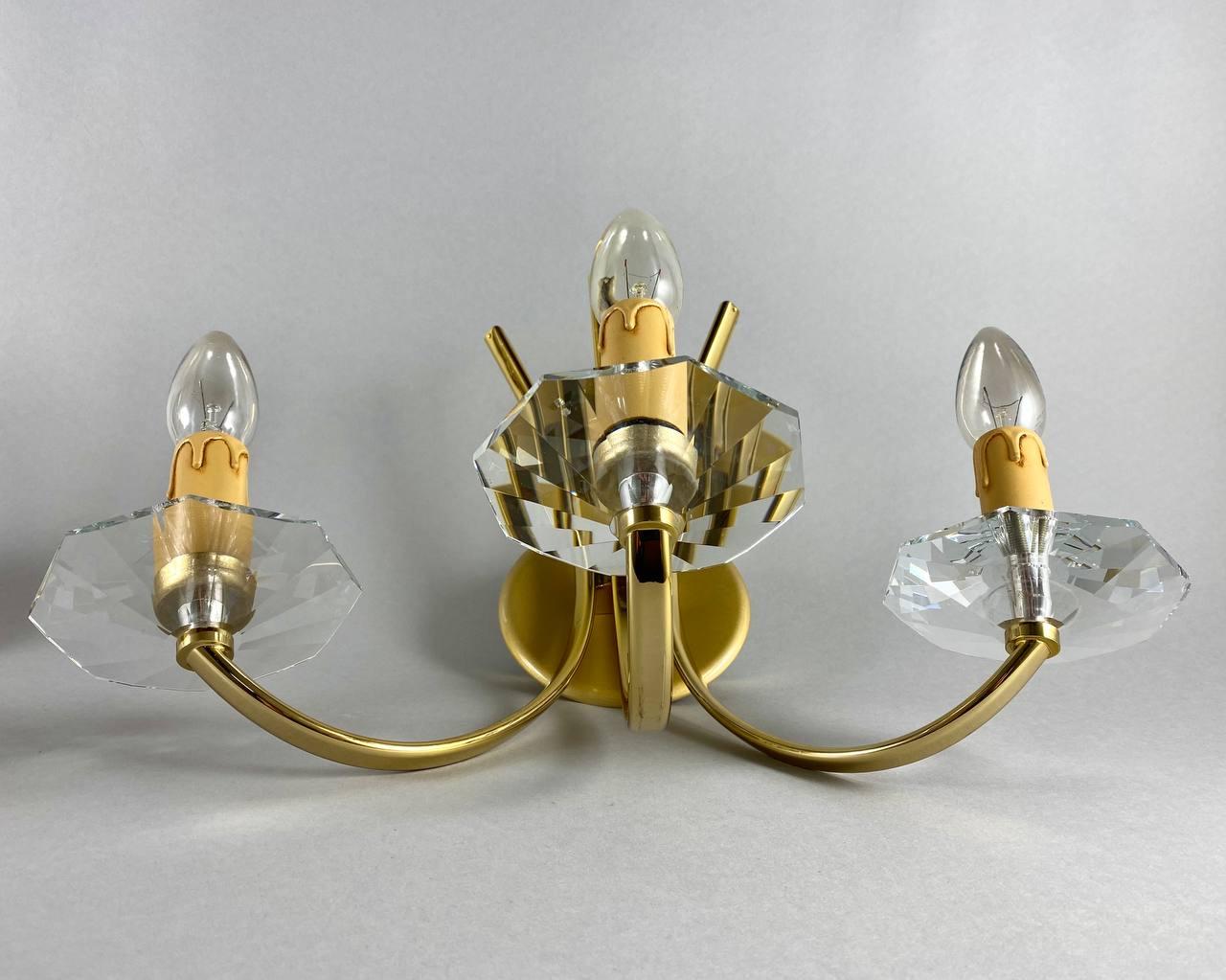 Classic designer sconces in gilt brass with three horns (candles) with crystal bobeche from the famous Portuguese company Candeeiros Castro.

Vintage designer wall lighting with 3 horns.

Very noble and sensual! Such a wall lamps will