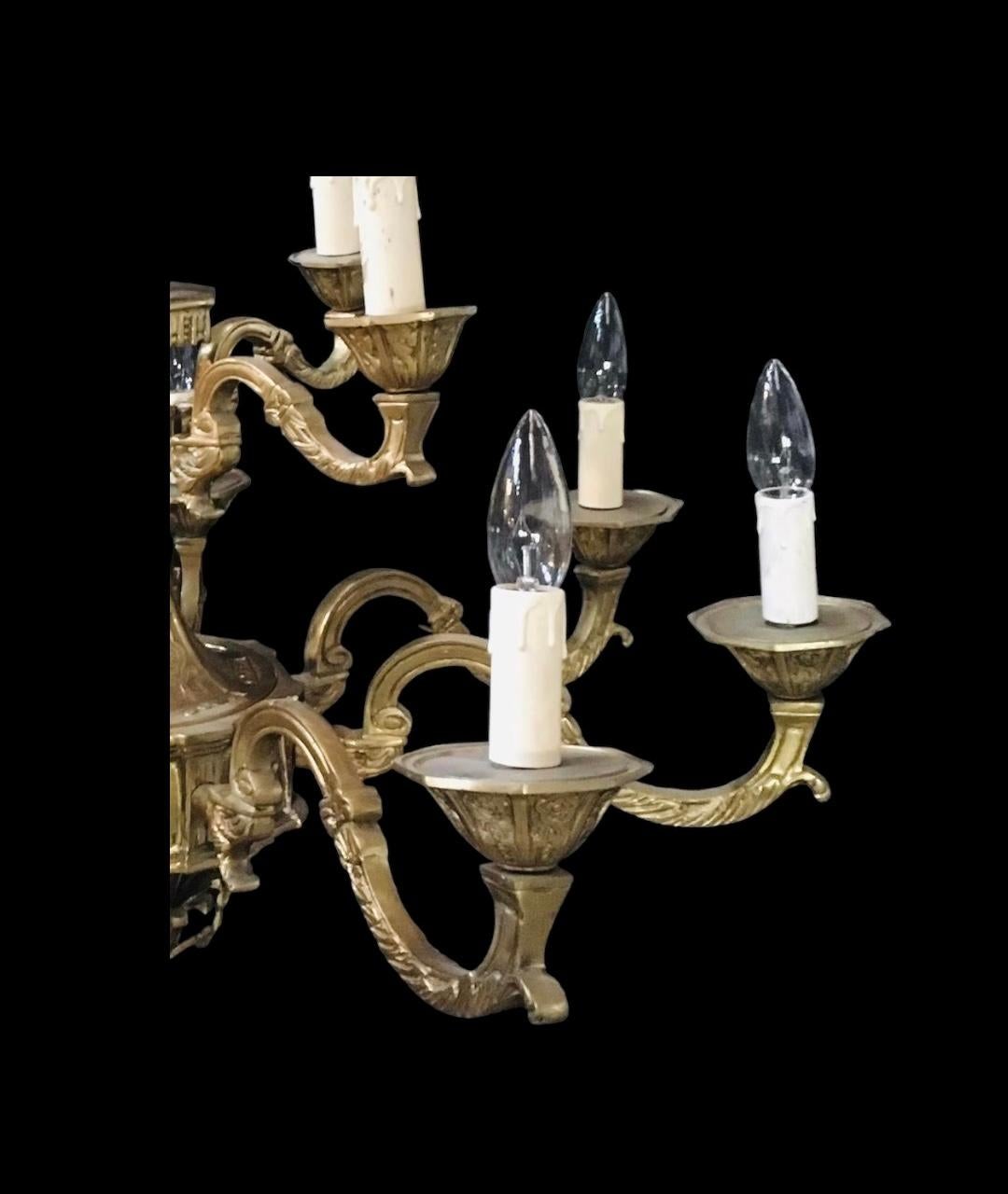 Hang the bronze light fixture above a dining room table or in an entryway to make an impressive French-style statement. The twelve-arm lights have been rewired to US standards and are embellished with decorative candle sleeve covers.