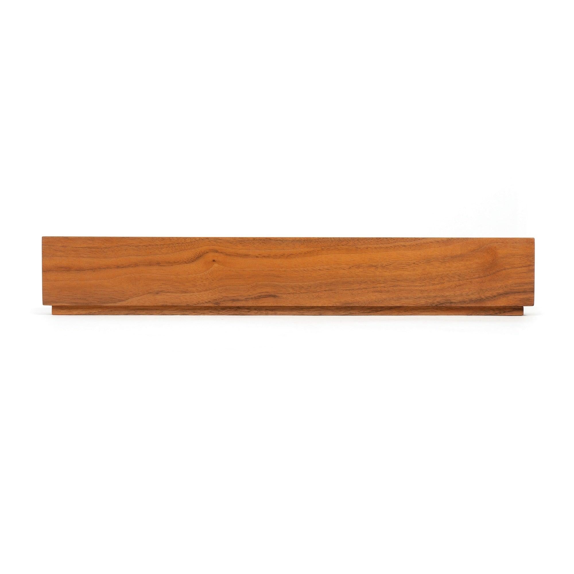 Un candelabro in noce realizzato con precisione da un pezzo di legno massiccio, su una piccola base a plinto.