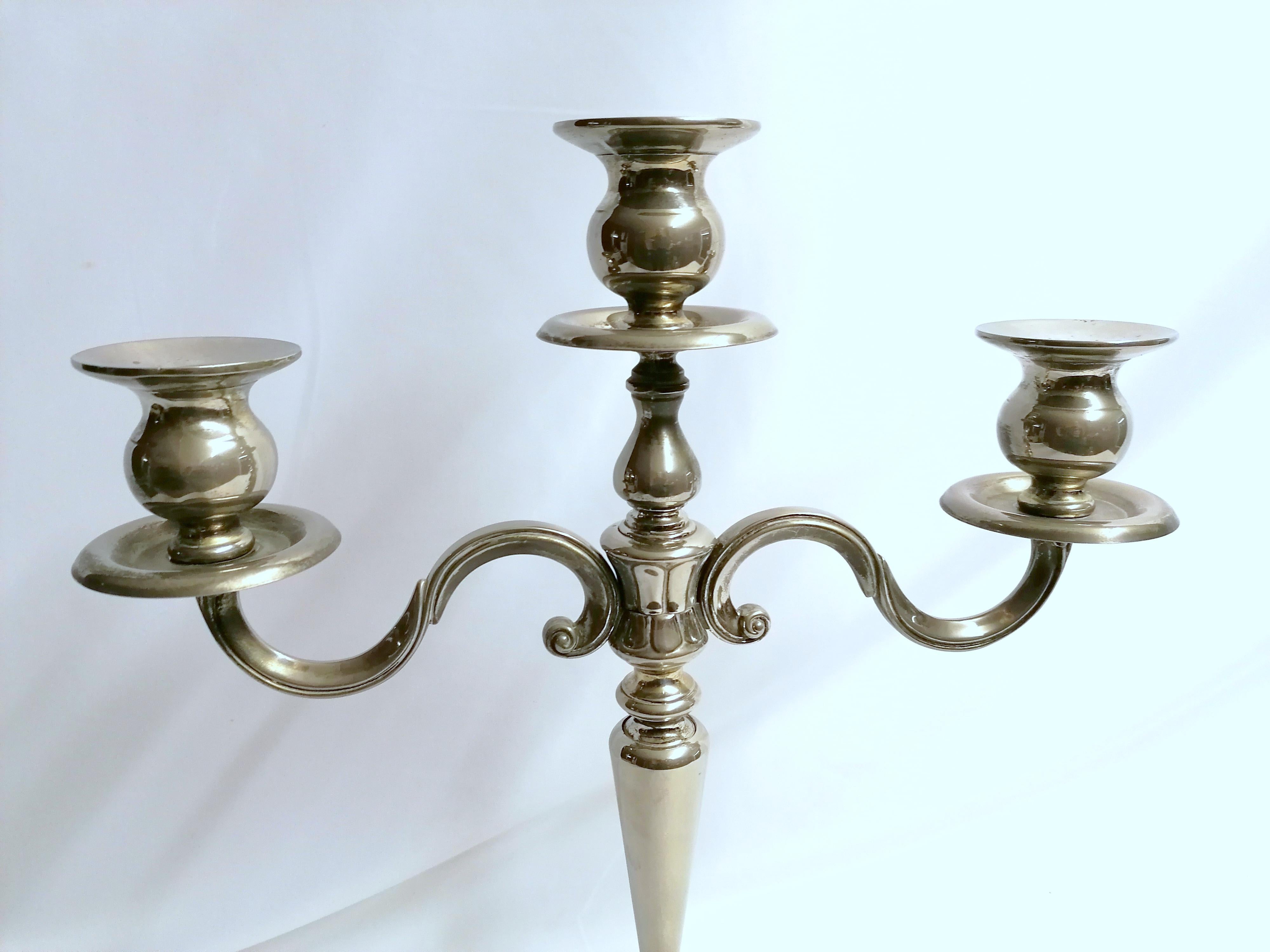 Renowned for designing exquisite silverware, this three-arm candelabra from Greggio's Inglese collection makes for a striking center piece. Finished in polished silver plating, the smooth curves are elegantly refined, complementing any home decor. I