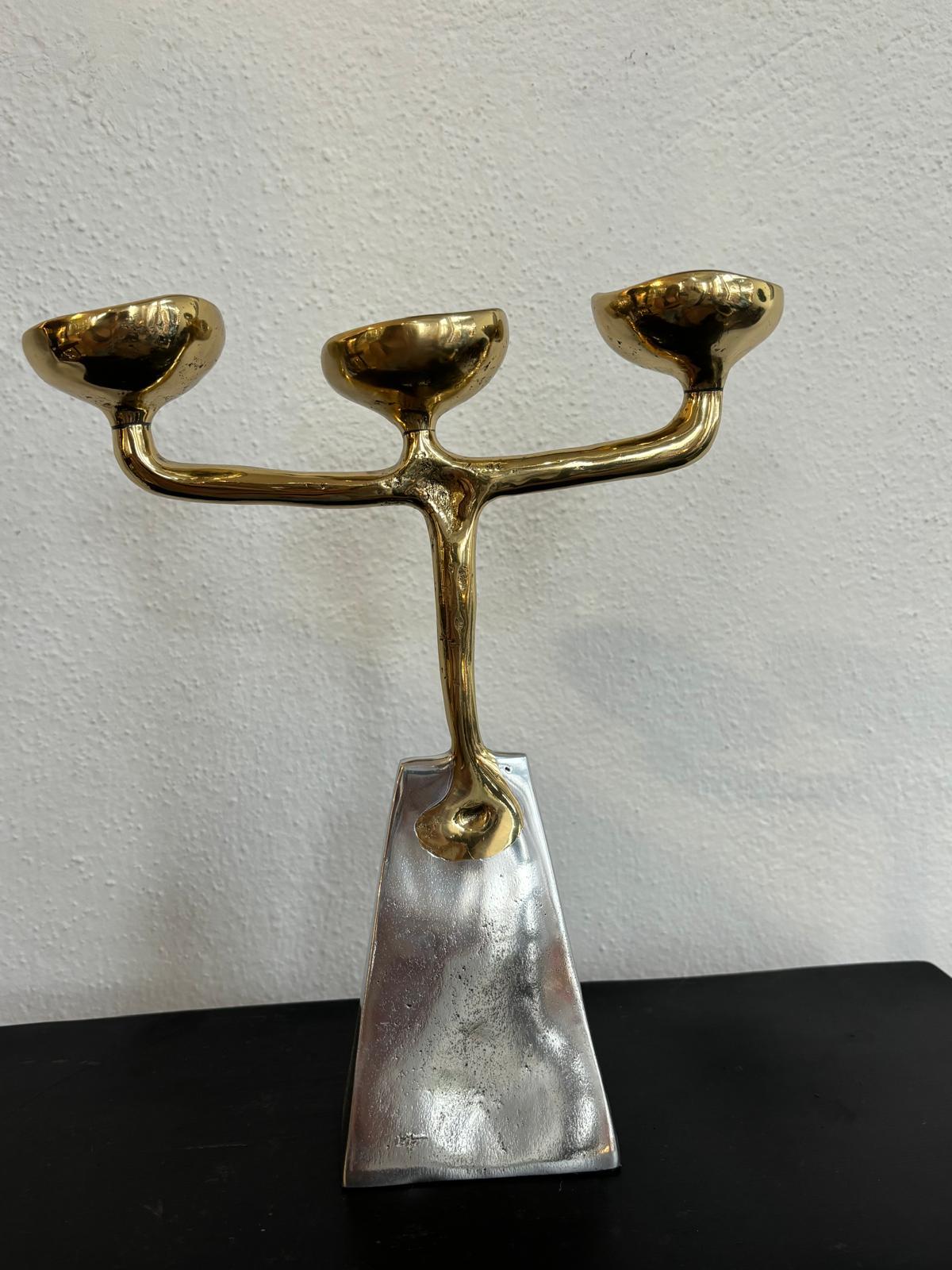 Il candelabro Piramide III è stato creato da David Marshall, in ottone e alluminio fusi in sabbia.
 Utilizziamo materiali riciclati e tutti i nostri pezzi sono fatti a mano, montati e rifiniti nella nostra fonderia e laboratorio in Spagna.
È