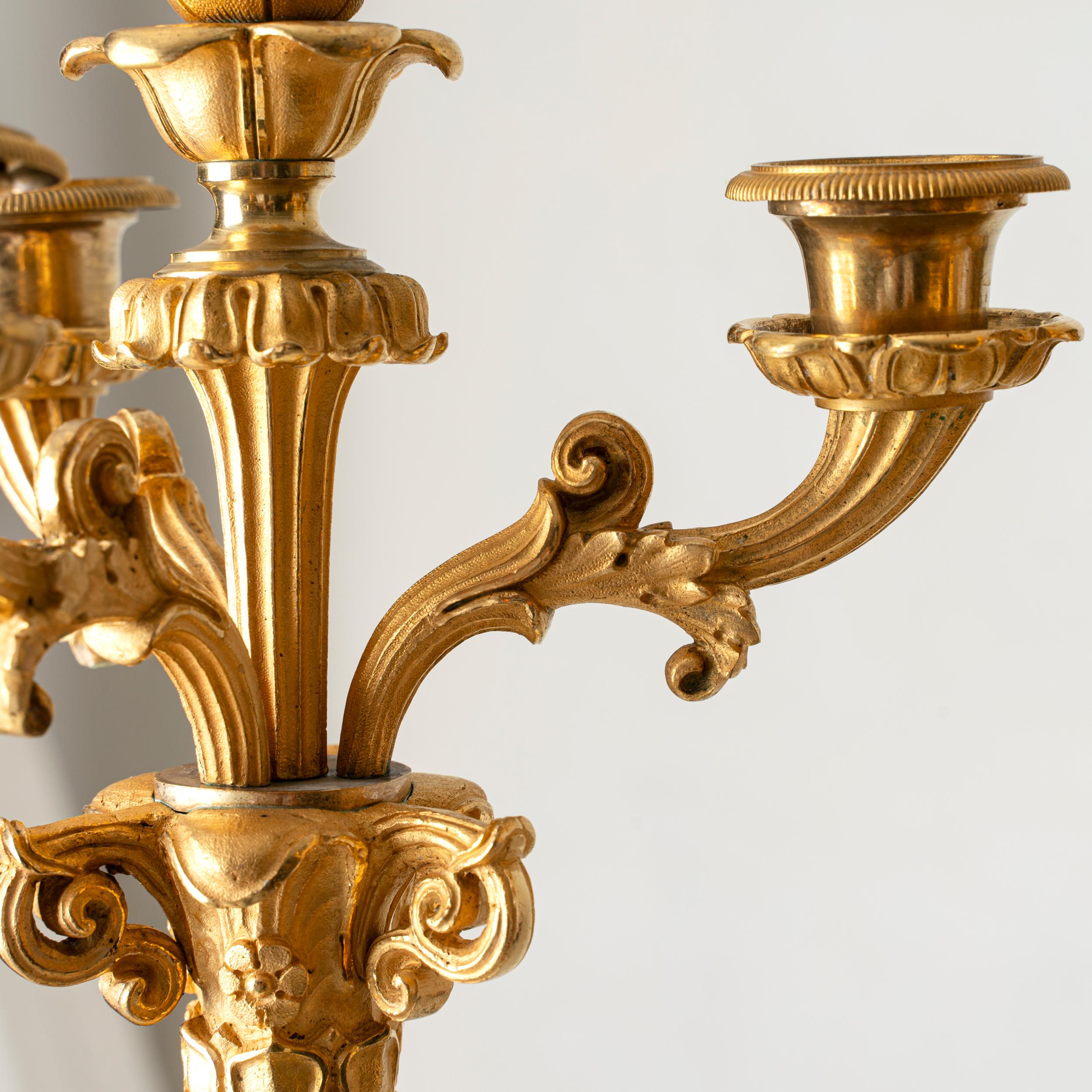 Una coppia di candelabri in bronzo dorato. Realizzato in Francia nel tardo stile Empie durante il XIX secolo. Portacandele superiore decorato con una torcia sciolta.