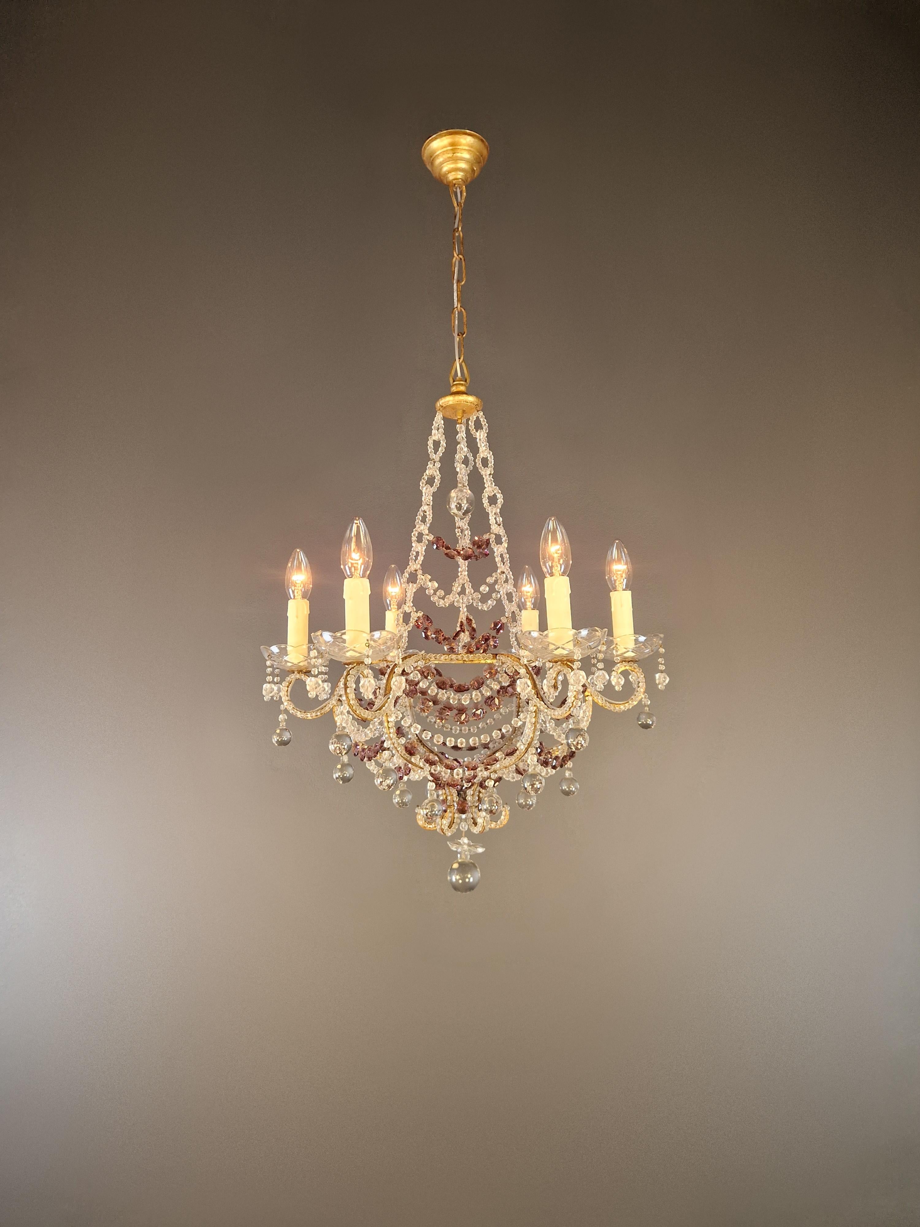 Voici notre exquis lustre en cristal antique, un chef-d'œuvre qui incarne l'élégance de l'Italie.

D'une hauteur de 100 cm (70 cm sans la chaîne) et d'un diamètre de 55 cm, ce lustre dégage un charme intemporel. Elle pèse environ 6 kg et comporte 6
