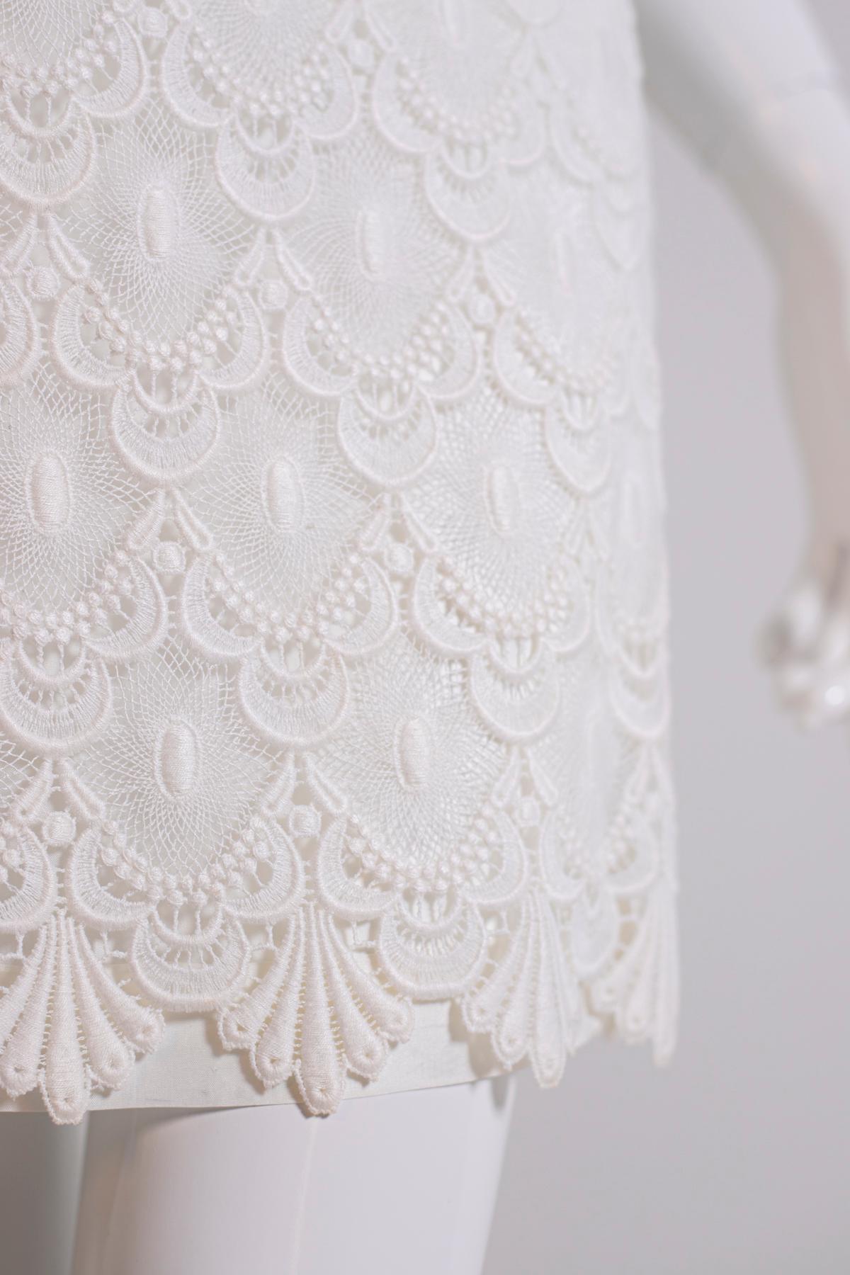 Robe en dentelle blanche des années 2000 d'Annabelle, fabriquée en Italie.
La robe est très jolie : courte jusqu'au-dessus des genoux, elle a un col haut et composé, pas de manches, mais de larges bretelles.
La robe descend très doucement, sans être