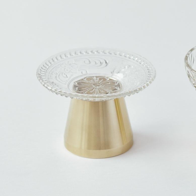 Bougeoir conçu par Ryosuke Harashima.
Cette œuvre est réalisée en plaque de verre antique japonaise et en laiton.
L'artiste crée un nouveau style de bougeoir en combinant du verre ancien et des matériaux industriels. Il possède à la fois un esprit