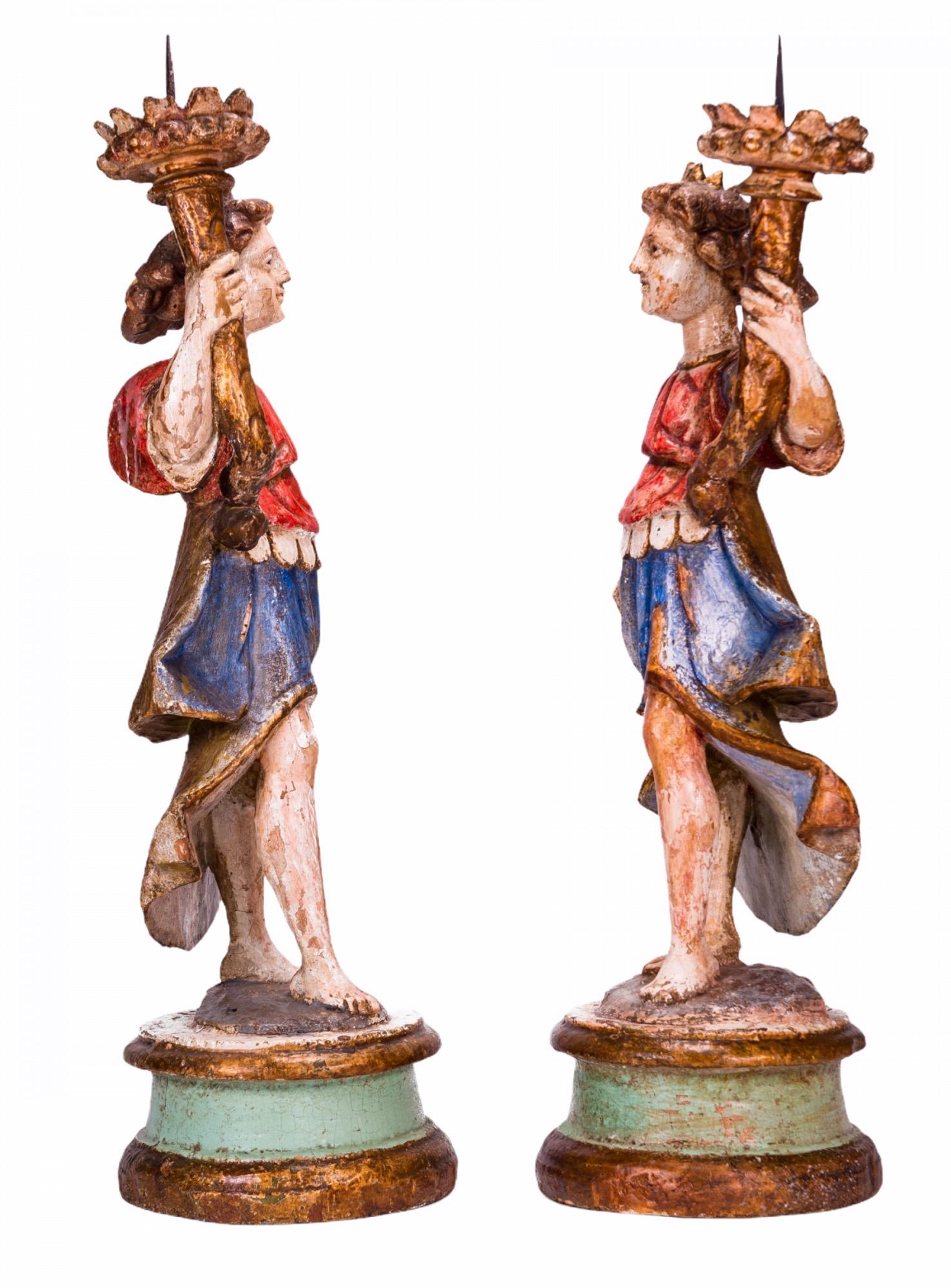 Ein Paar barocke, polychromierte, geschnitzte Engelsskulpturen aus Holz mit fackelförmigen Kerzenhaltern aus dem frühen 17. Jahrhundert.
