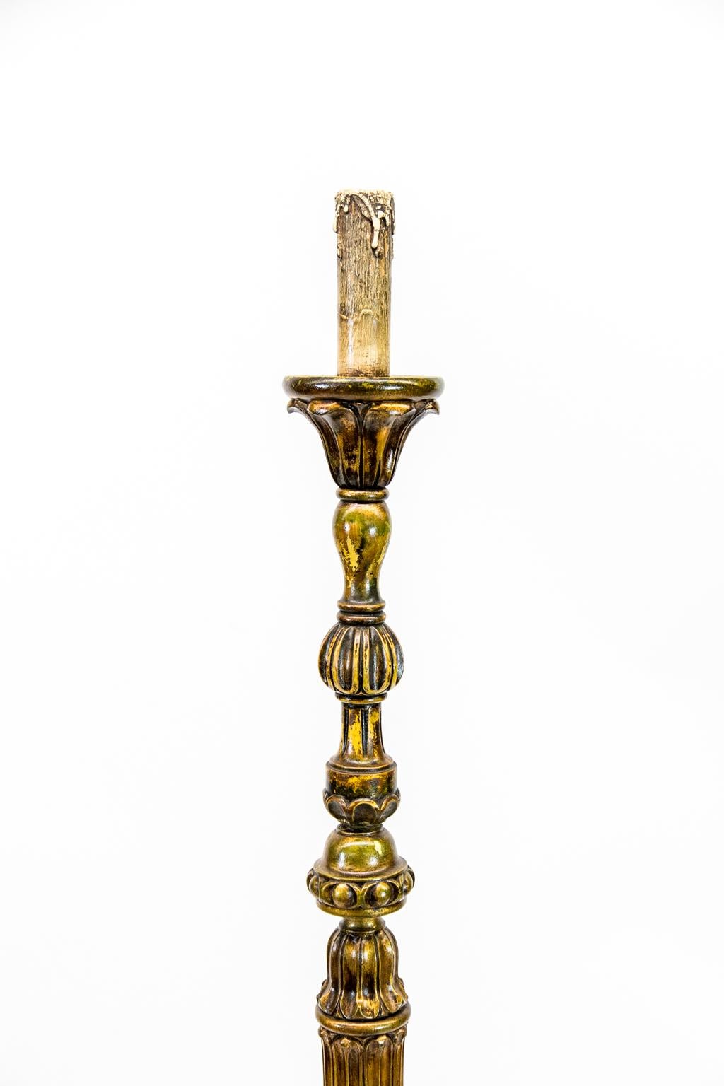Questo portacandele/lampada da terra ha uno stelo con vari motivi intagliati nella parte superiore. L'area centrale è scanalata e termina con una base a foglie d'acanto stilizzate che poggia su una piattaforma a tre anelli concentrici. La base ha