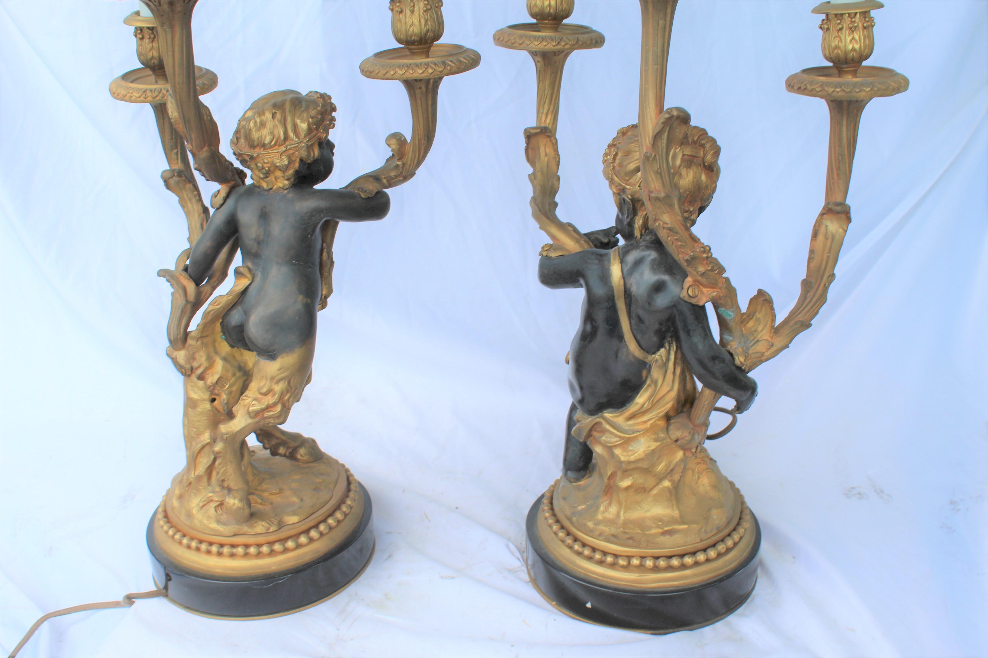 A Fine pair of Cherub candelabras cast in Lost Wax bronze with fine details and black patina and 18-karat Doré gold-plated made  from the originals of Clodion. Wired and ready. Have been held in private bronze collection. Mounted on absolute black