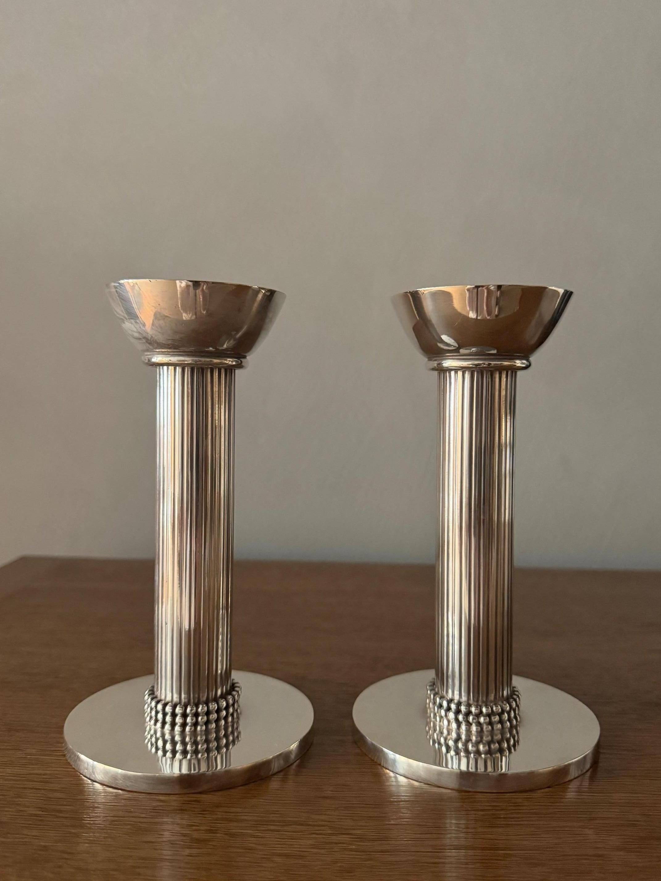 Wunderschönes Paar versilberter Bronzeleuchter von Jean Deprés (1889-1990), beide vom Künstler signiert. Deprés war ein französischer Schmuckhersteller und Designer. Seine Werke befinden sich in den Sammlungen des Musée d'Art Moderne in Paris und