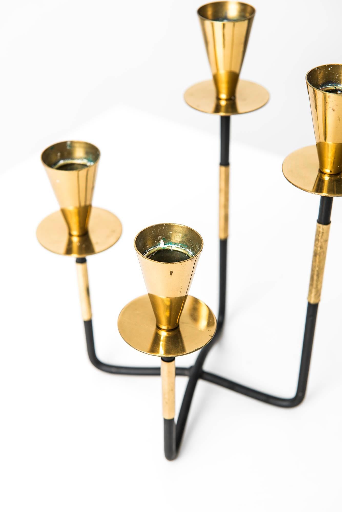 Candlestick in brass and black lacquered metal. Produced by Nils Johan in Sweden.