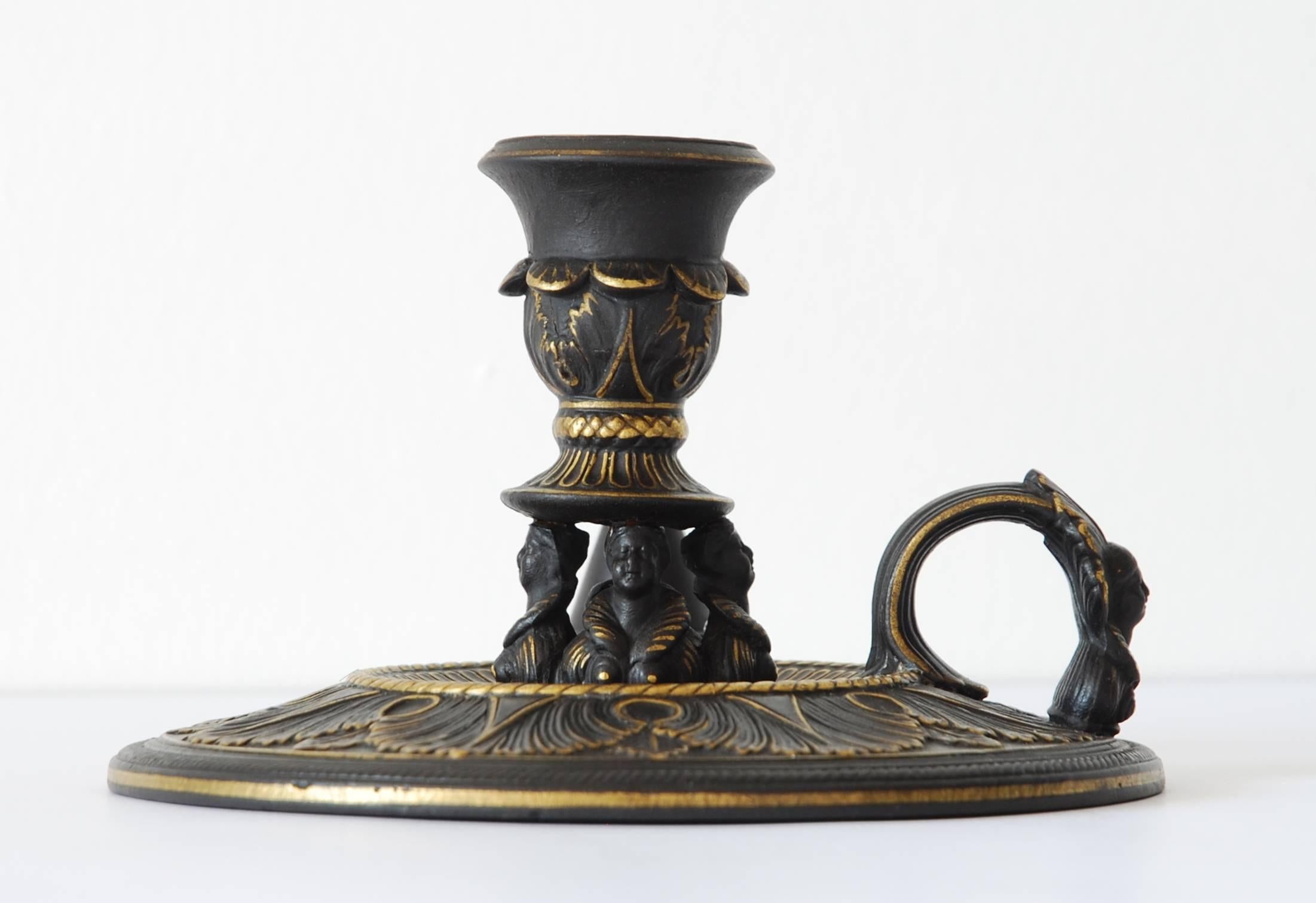 In black basalt, with gilt highlights. The design is most unusual, with numerous busts of Queen Elizabeth I supporting the sconce.
