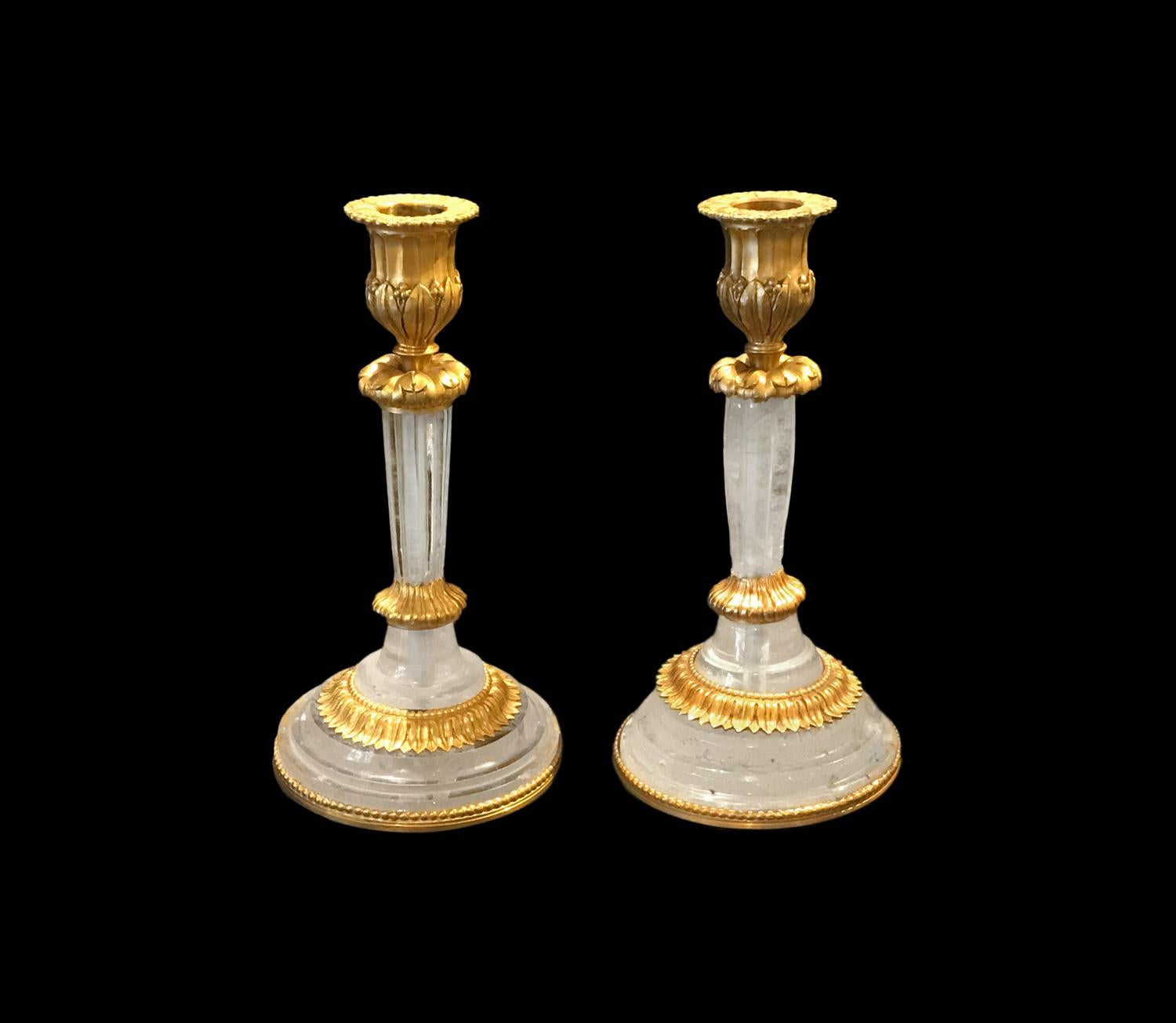 Paire de chandeliers en cristal de roche sur une monture en bronze doré de style Louis XVI. Base circulaire moulurée avec des ornements en bronze doré tels que des frises de perles et de feuilles d'eau, également visibles sur le binet.

Très beau