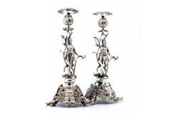 Candlesticks with floral cut bases, figures and three dolphin-shaped feet