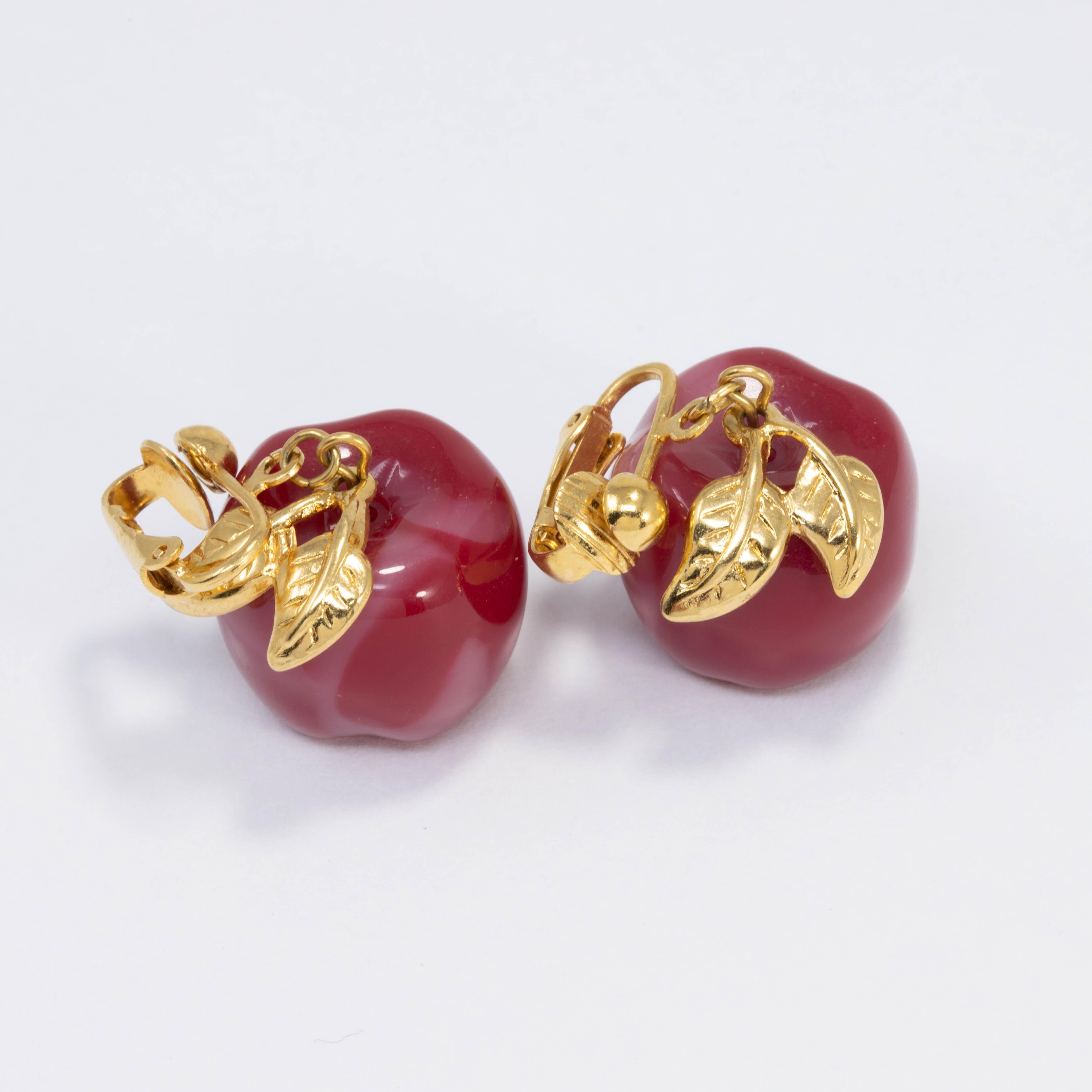 A pair of vintage bakelite earrings. Features an red bakelite apple dangling from a vintage clip on in goldtone.