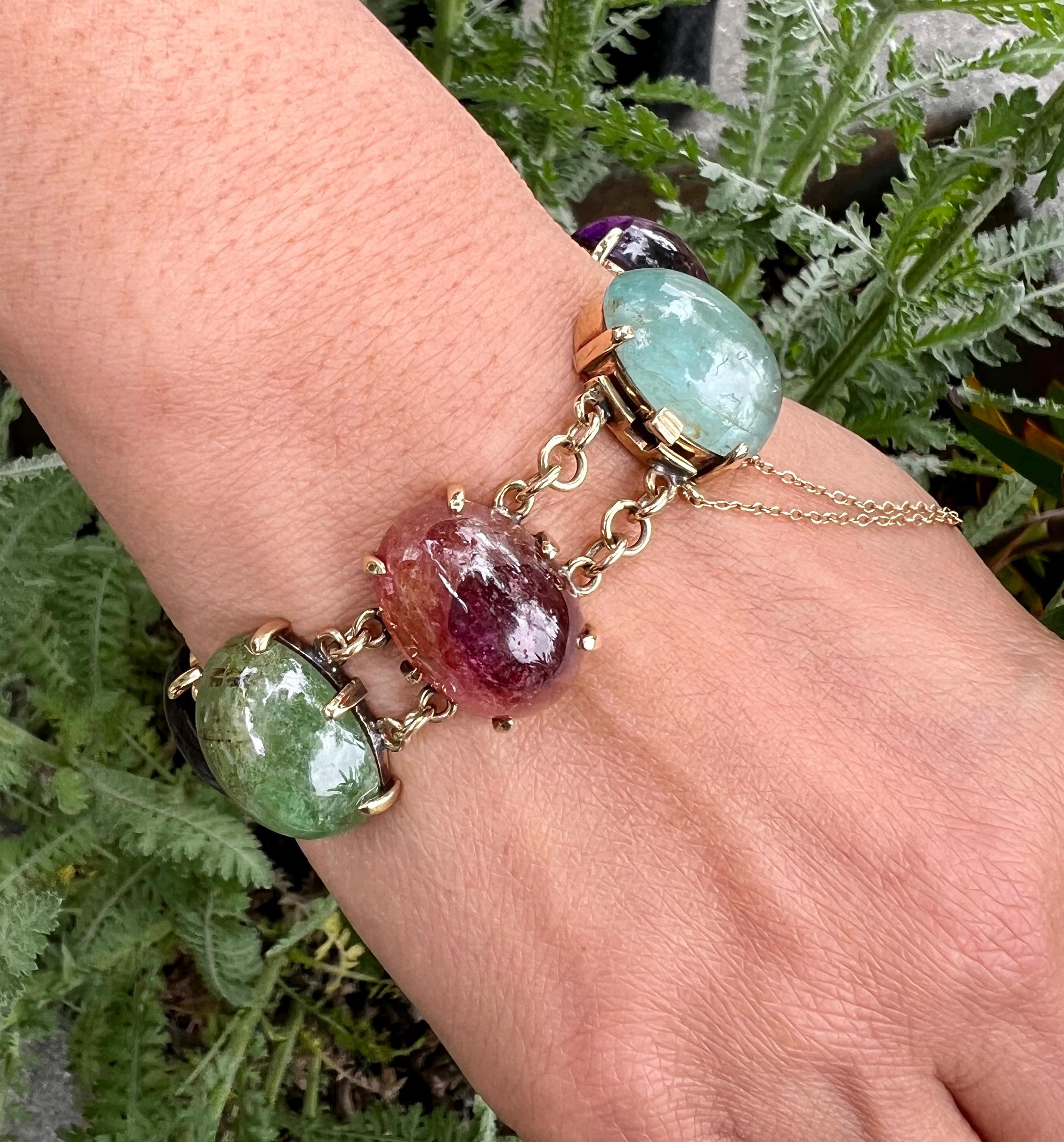 This stunning bracelet is a lovely, warm combination of natural stones consisting of watery Aquamarine, Amethyst, Topaz, Green Tourmaline and Sapphires set in 14 karat gold. It is very comfortable to wear and has a secure clasp with a safety chain.