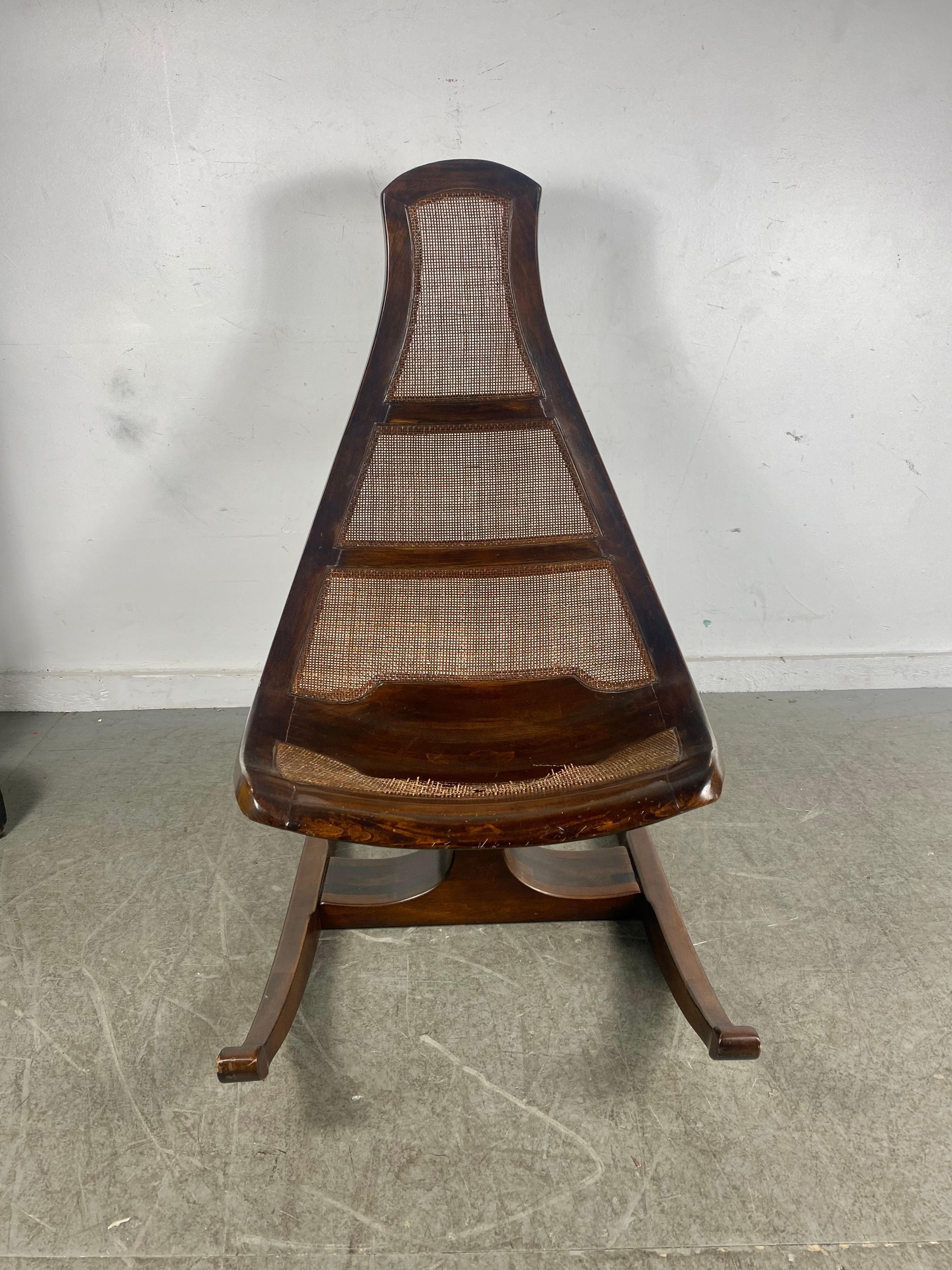 Sculptural Brazilian rocking chair in the style of Joaquim Tenriero. Amazing quality and design. Original cane seat in need of restoration. (see photo). Hand delivery avail to New York City or anywhere en route from Buffalo NY.