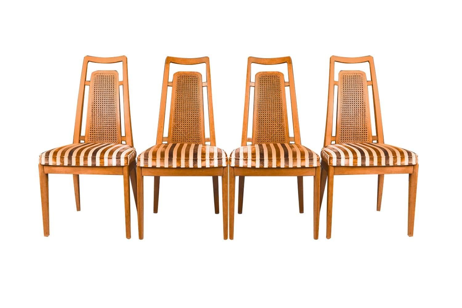 A set of six gorgeous, modern dining chairs designed by Drexel Heritage for Drexel’s Meridian Collection, circa 1960’s. The pecan cane frames feature modern styling with a distinct beautiful design. Sculpturally carved and woven caned backrests with