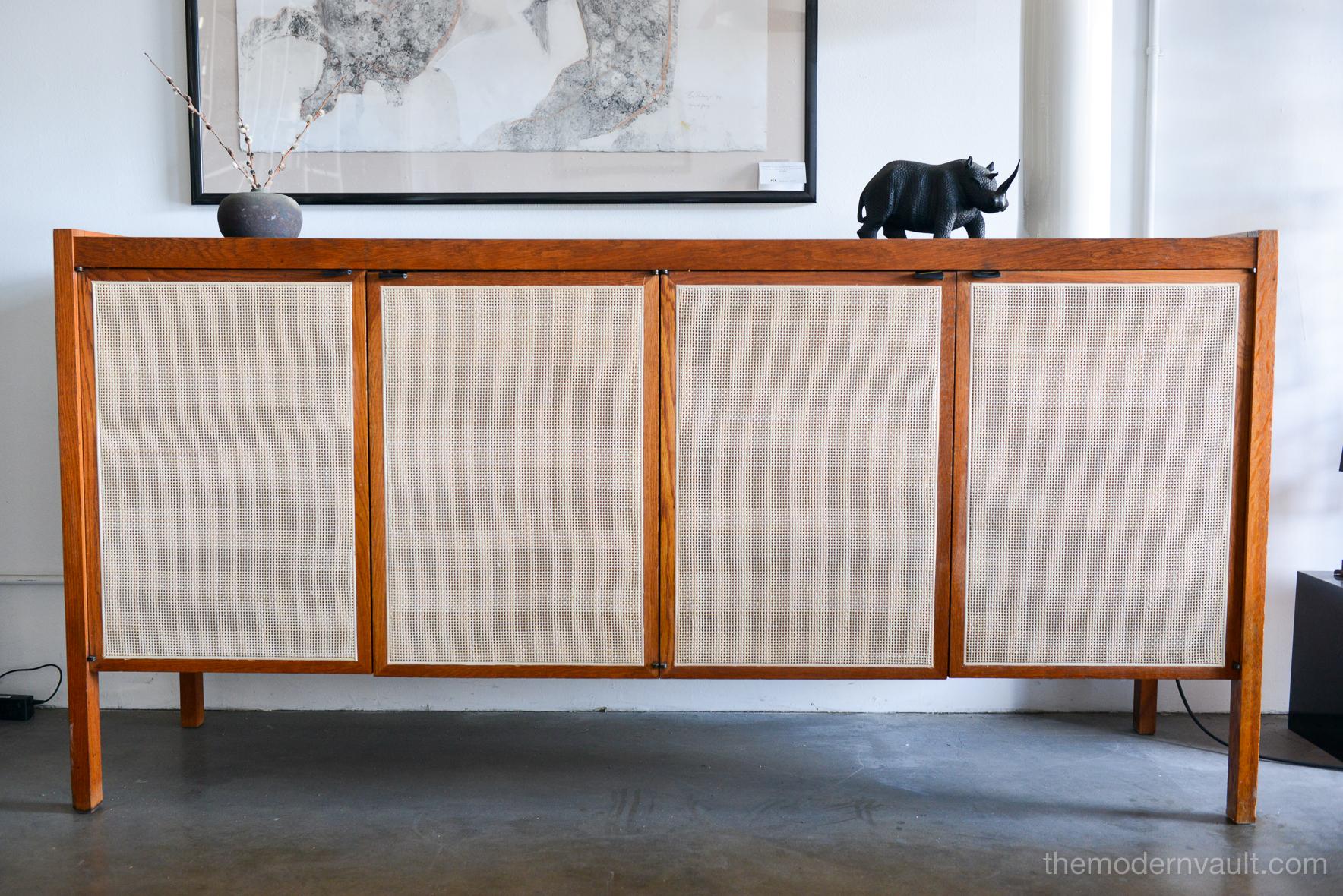Cane front credenza with micarta top by Jack Cartwright, circa 1960. New coordinating black leather pulls and new cane doors. Oak frame with teak side panels in very good condition. Substantial, large piece perfect for a credenza or dining room