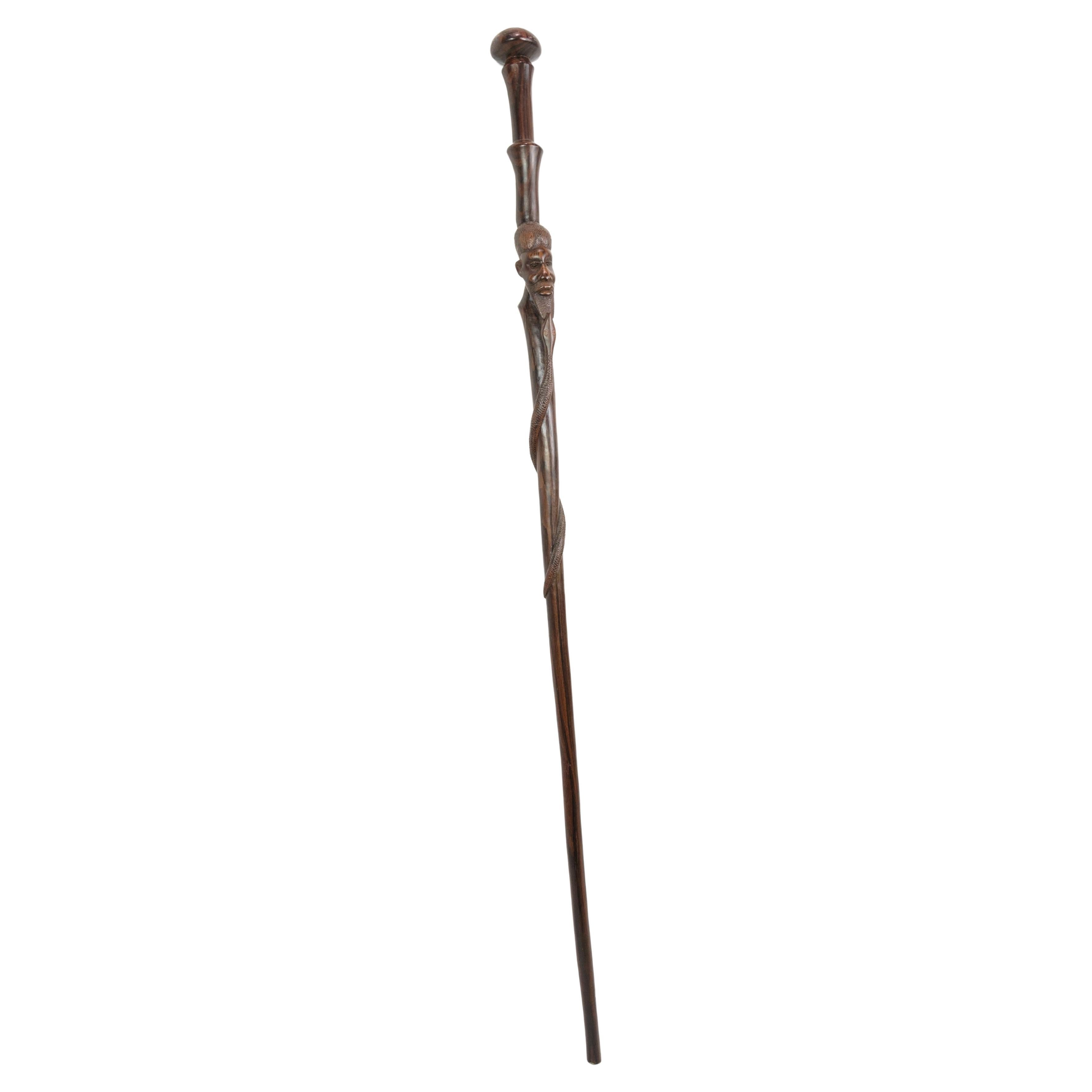 Cane in rosewood with a carved motif of a man being bitten by a snake 1960
