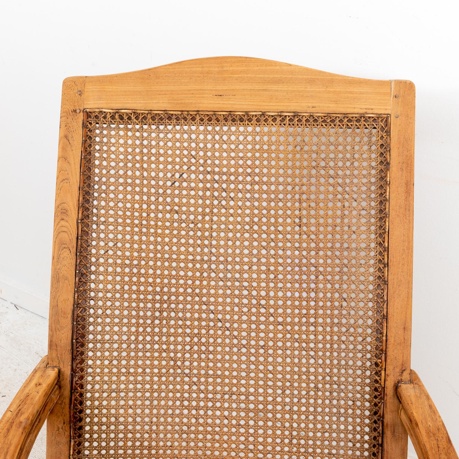 Cane woven plantation armchair with arrow turned legs. The chairs also feature octagonal woven cane. Please note of wear consistent with age including wood loss, chips, and heavy patina loss.