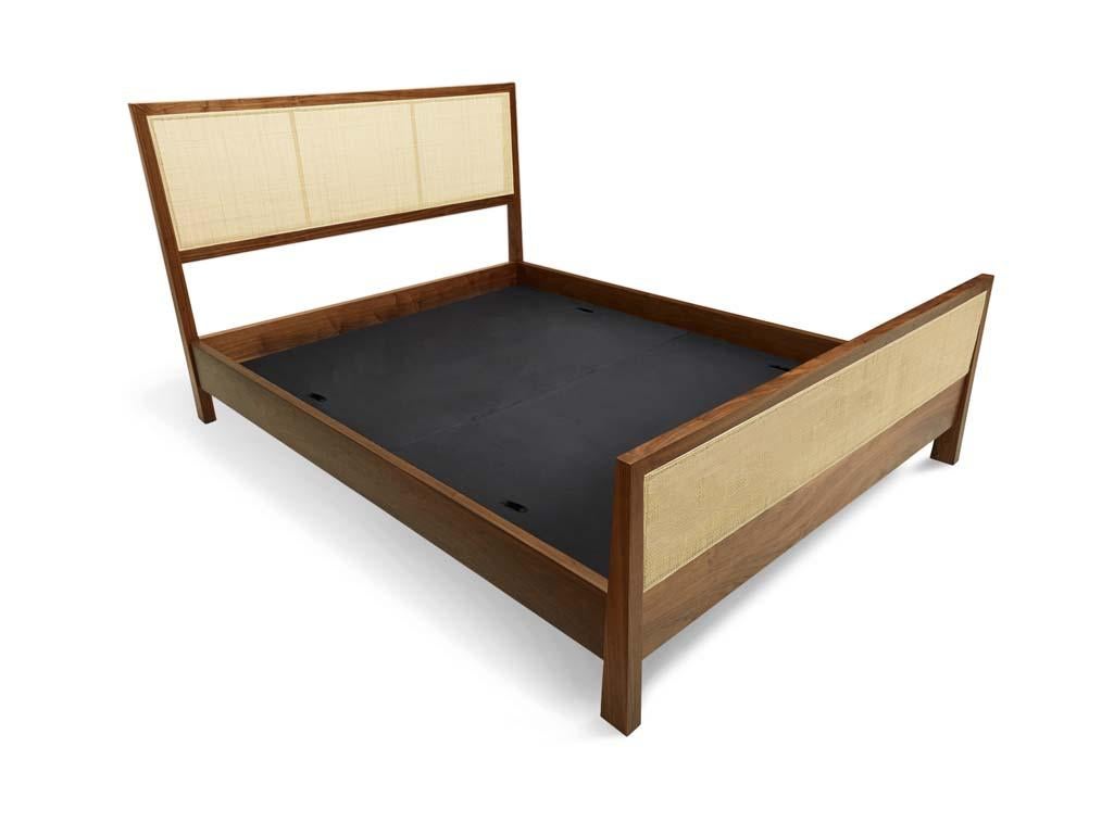 The Caned bed is a solid wood framed bed that can be made in either white oak or American walnut. The piece features a headboard and footboard or just a headboard made with natural cane inset panels and brass stretchers. Slats are provided.

The