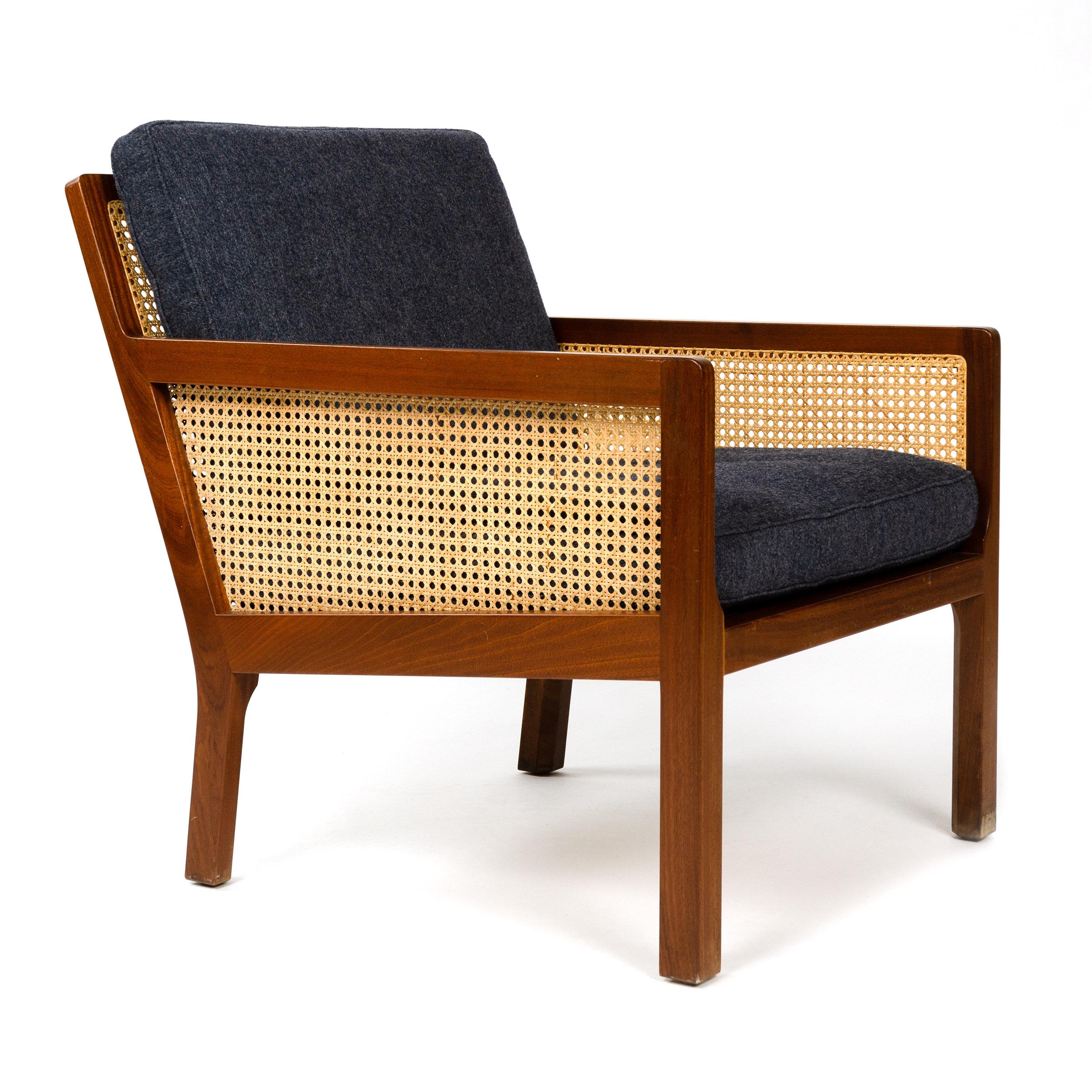 A mahogany lounge chair with traditional hand-caned back and side panels with newly upholstered black Savak wool, seat and back cushions. Designed by Bernt Petersen and crafted by Worts Mobelsnedkeri in Denmark, circa 1962.