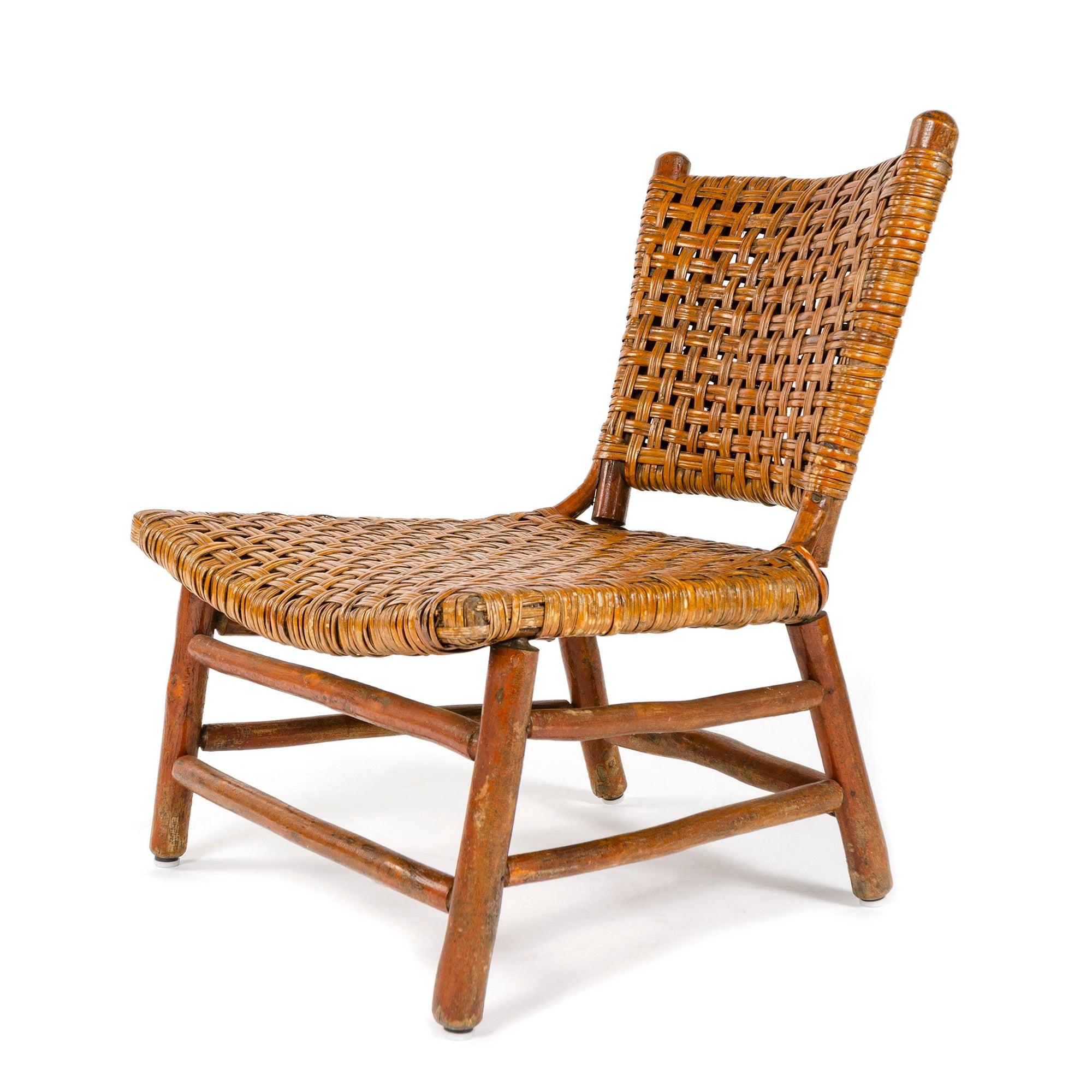 Ein Loungesessel aus gelber Birke mit geflochtener Sitzfläche und Rückenlehne.