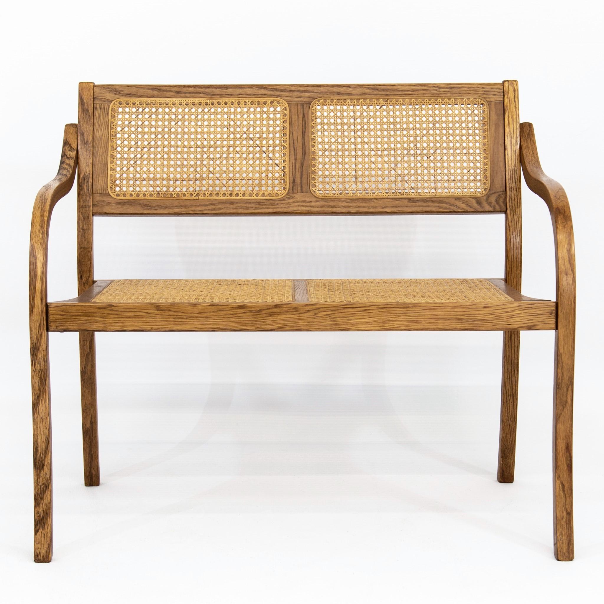 Mid-century beautifully grained oak settee, bench or loveseat with bentwood arms and caned back and seat. Seat, 18