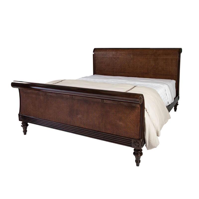 A Regency style Anglo-Indian bed. With a modestly scrolled headboard and footboard with caned panels. Reeded rails, flowerhead carved roundels, scroll carvings and turned tapered legs add authenticity and charm.

Shown in Cambridge Finish
For US