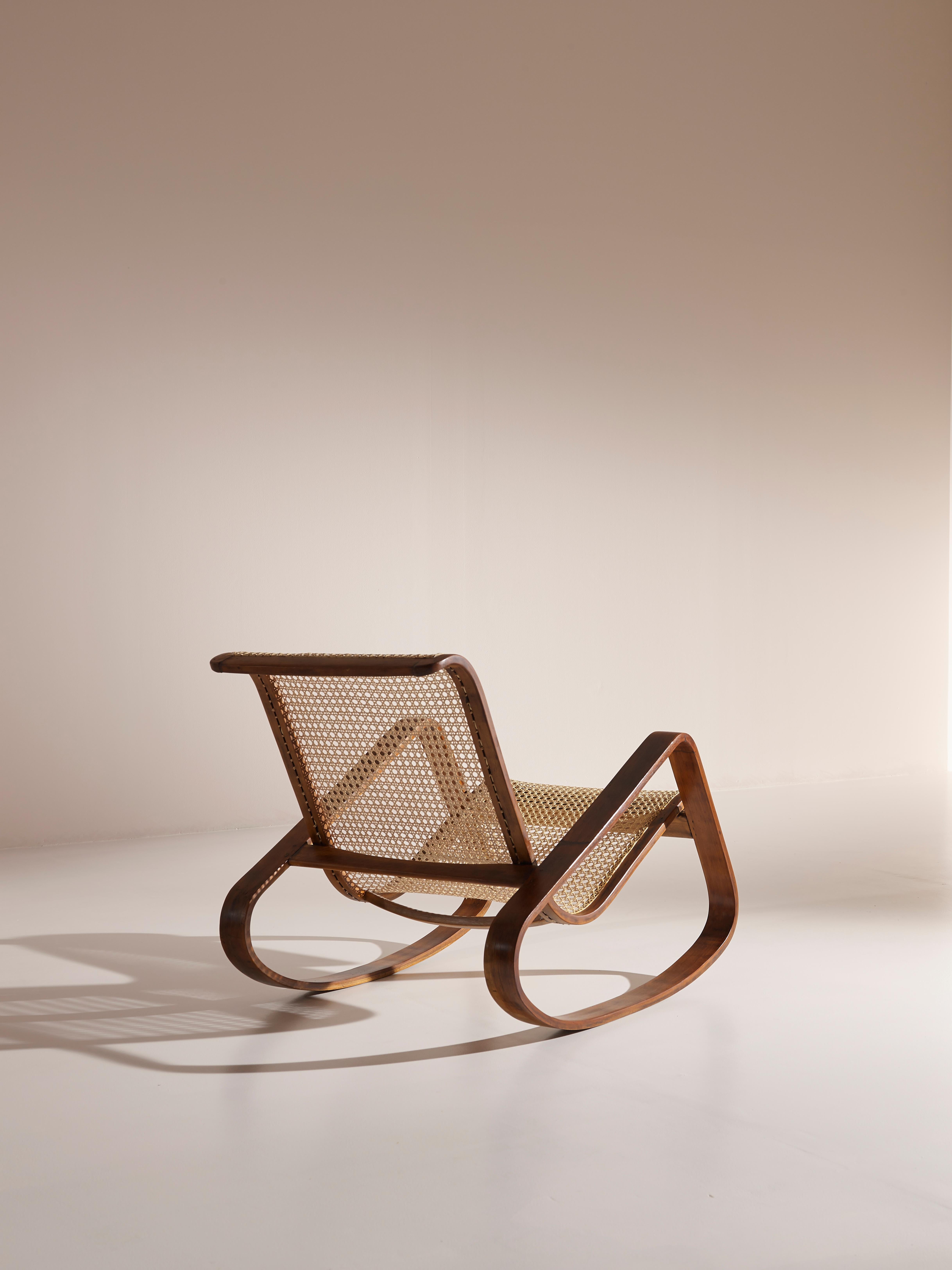 An exceptional and very rare rocking chair designed and produced by Ditta Porino (Torino - Italy) in the 1930s.

The design of this piece is simply stunning in its simplicity. A single piece caned seat lays with lightness on two organically shaped