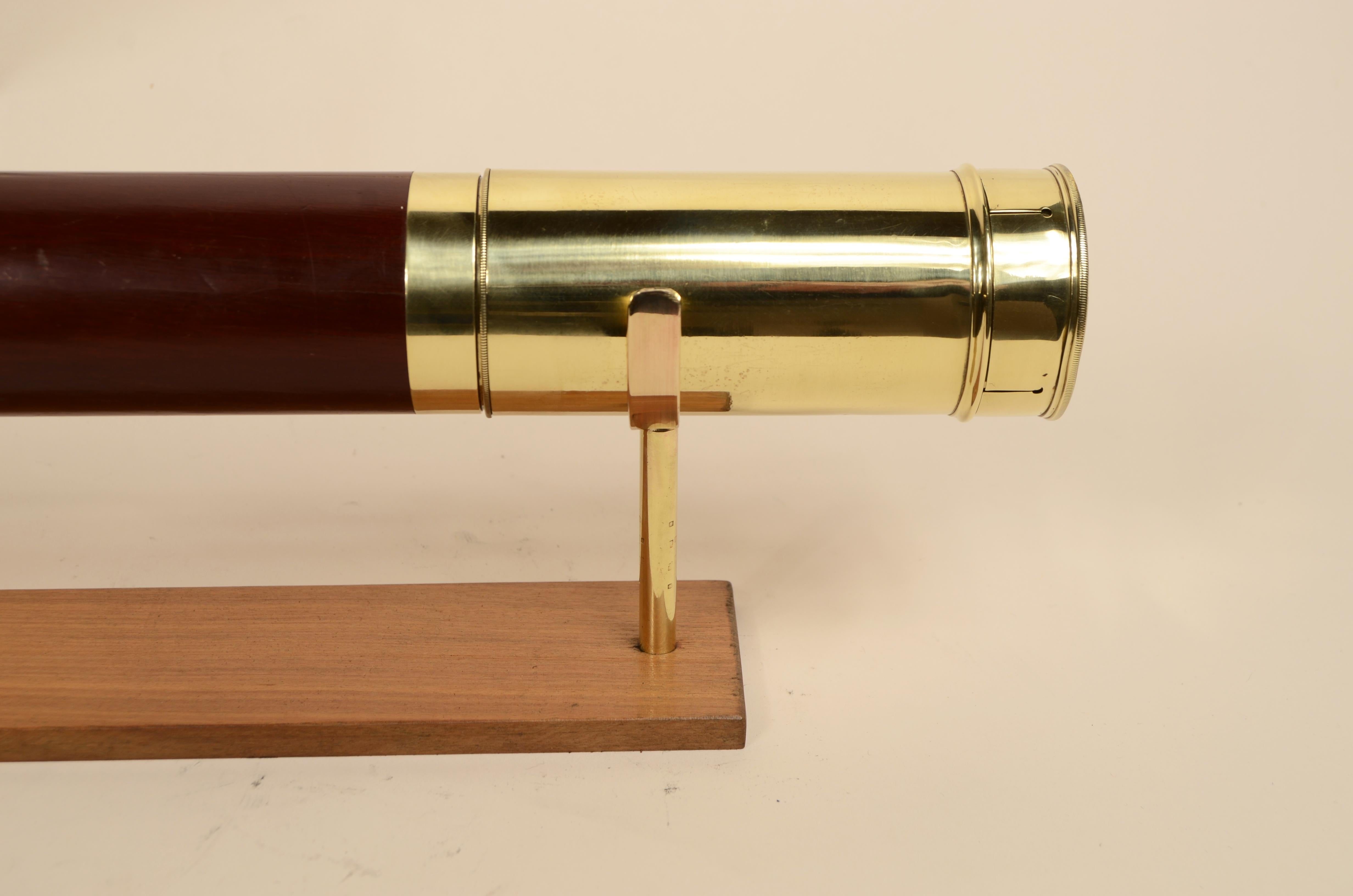 Télescope rond en laiton avec poignée en bois d'acajou, mise au point avec trois extensions, complet avec capuchon, extension pare-soleil  et la languette du couvercle anti-poussière. 
Fabrication anglaise du milieu du 19e siècle. 
En bon état,